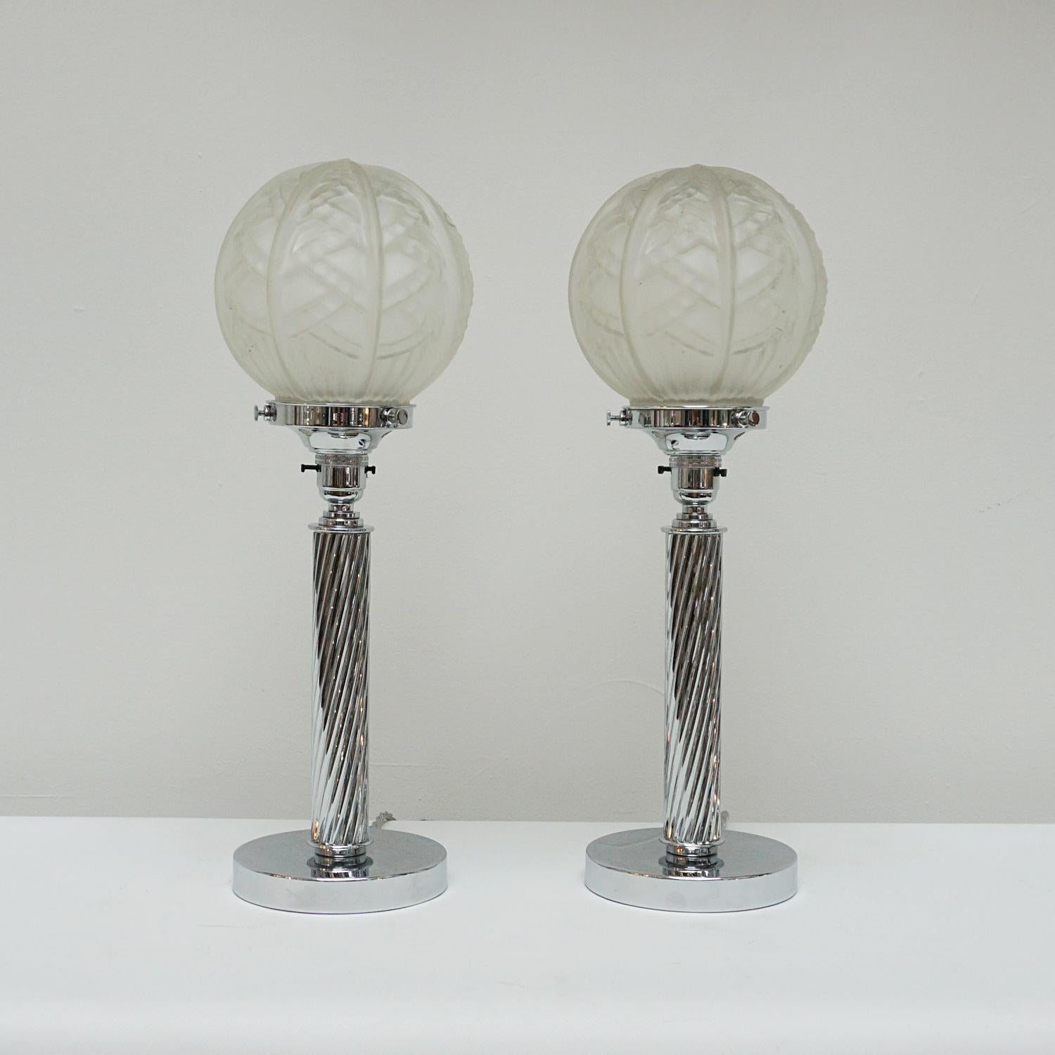 A pair of Art Deco table lamps. Finely spiralled chrome column stem, set over stepped circular base. Segmented frosted glass shades shades. 

Dimensions: H 49cm 

Origin: English

Item Number: J291

All of our lighting is fully refurbished,