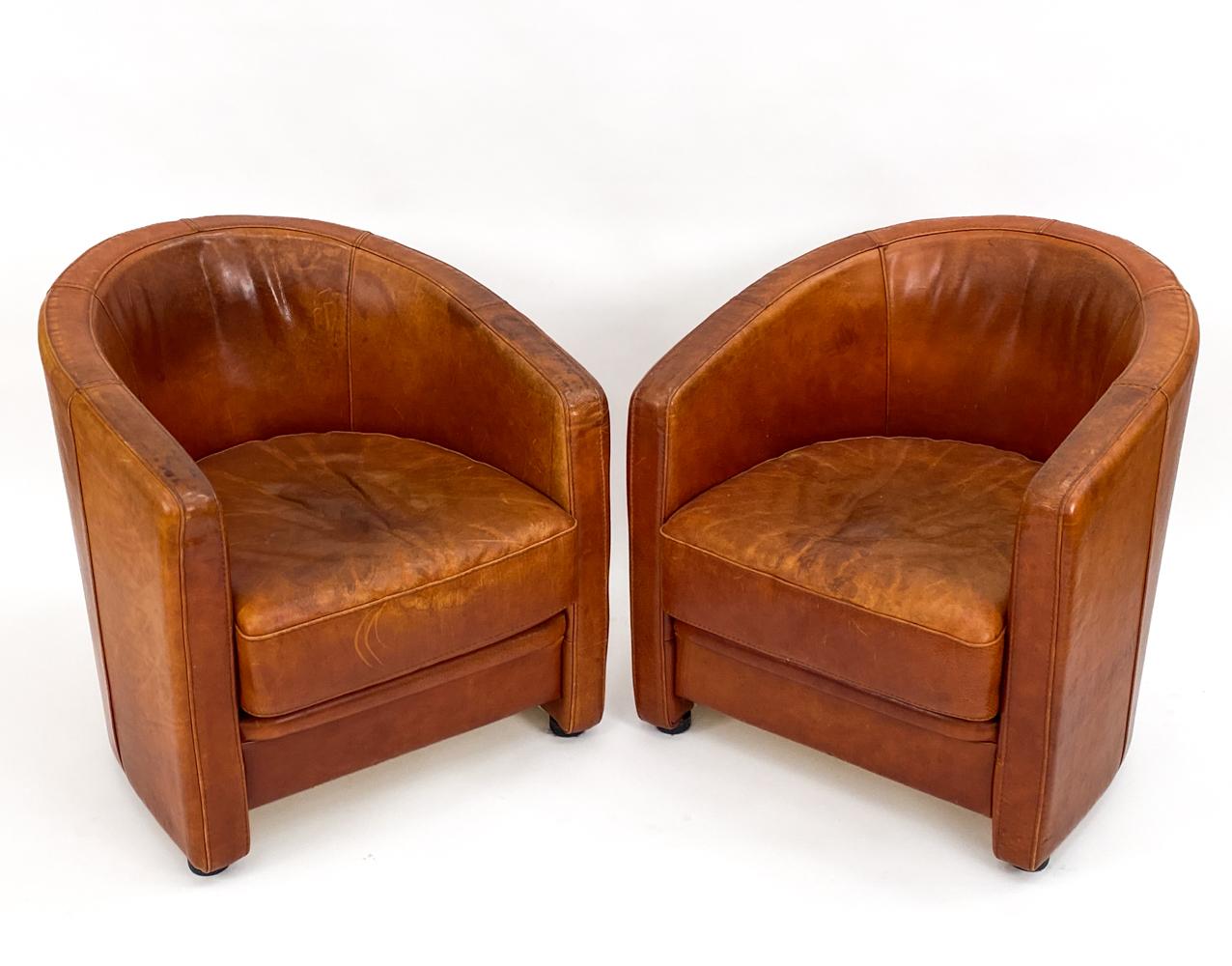 Add a touch of handsome luxury to your library or sitting room with this timeless pair of leather club chairs attributed to Anton Dam. These chairs have a great Art Deco look, with boldly curved barrel backs, clean lines and proportions that are