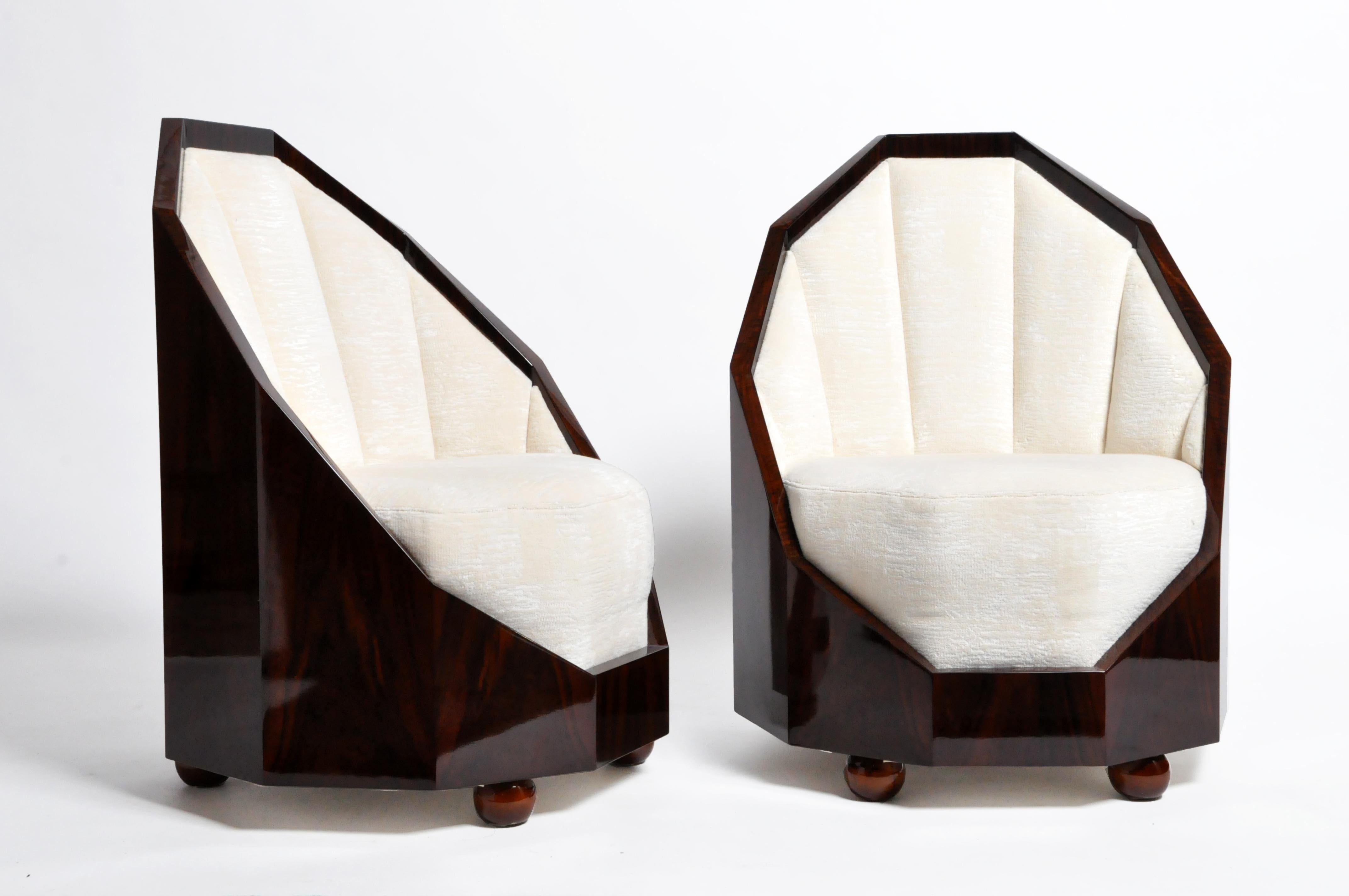 High-gloss decagon frames surround the plush circular seats of these petite chairs. Handsome velvet-like upholstery further accentuates the paneled backs, and both are raised on ball feet.