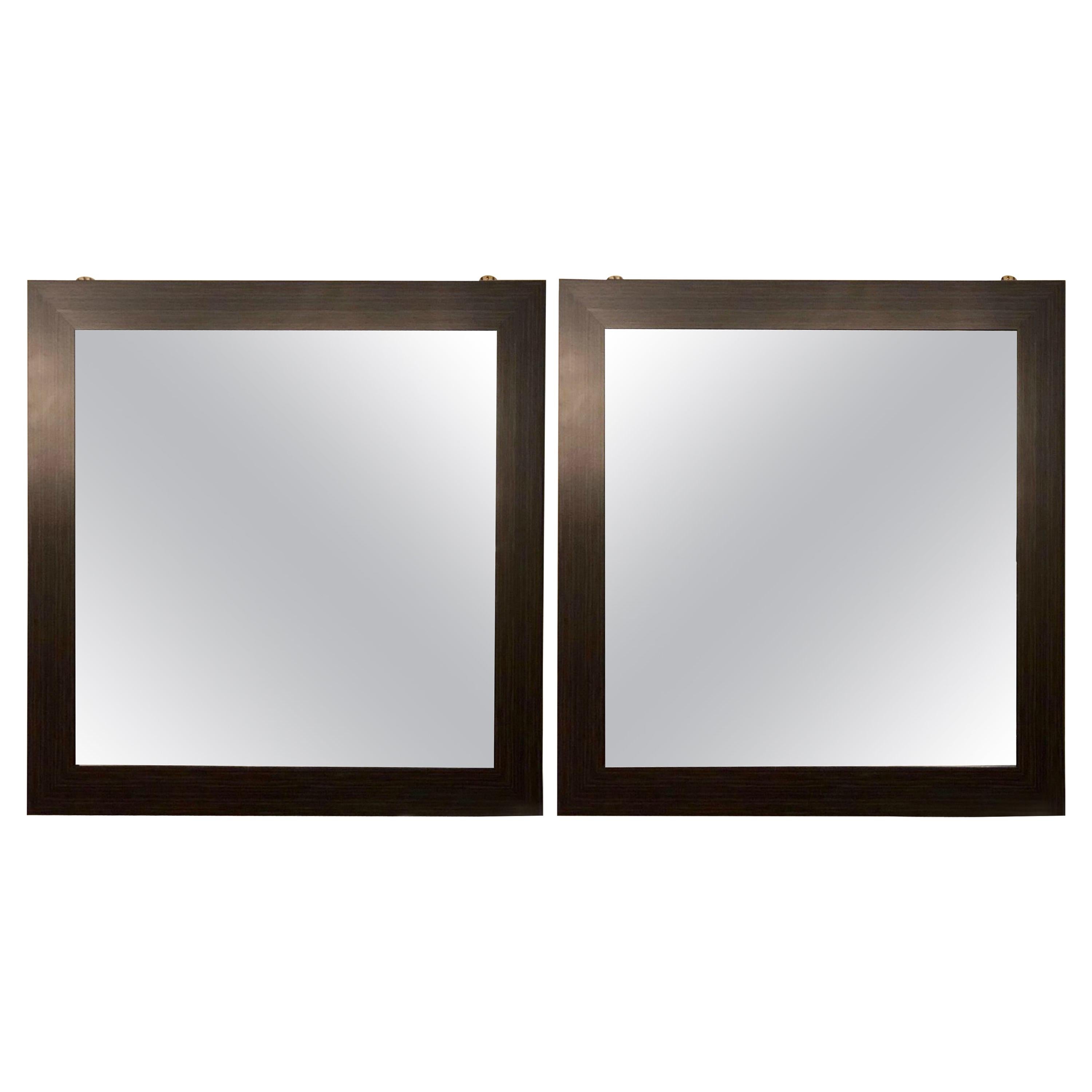 Pair of Art Deco style faux Macassar square console or wall mirrors. Purchased from a hotel in France we have one dozen of these squarish wall or console mirrors. Each having an etched circular in the center of the clear mirror set in a rosewood or