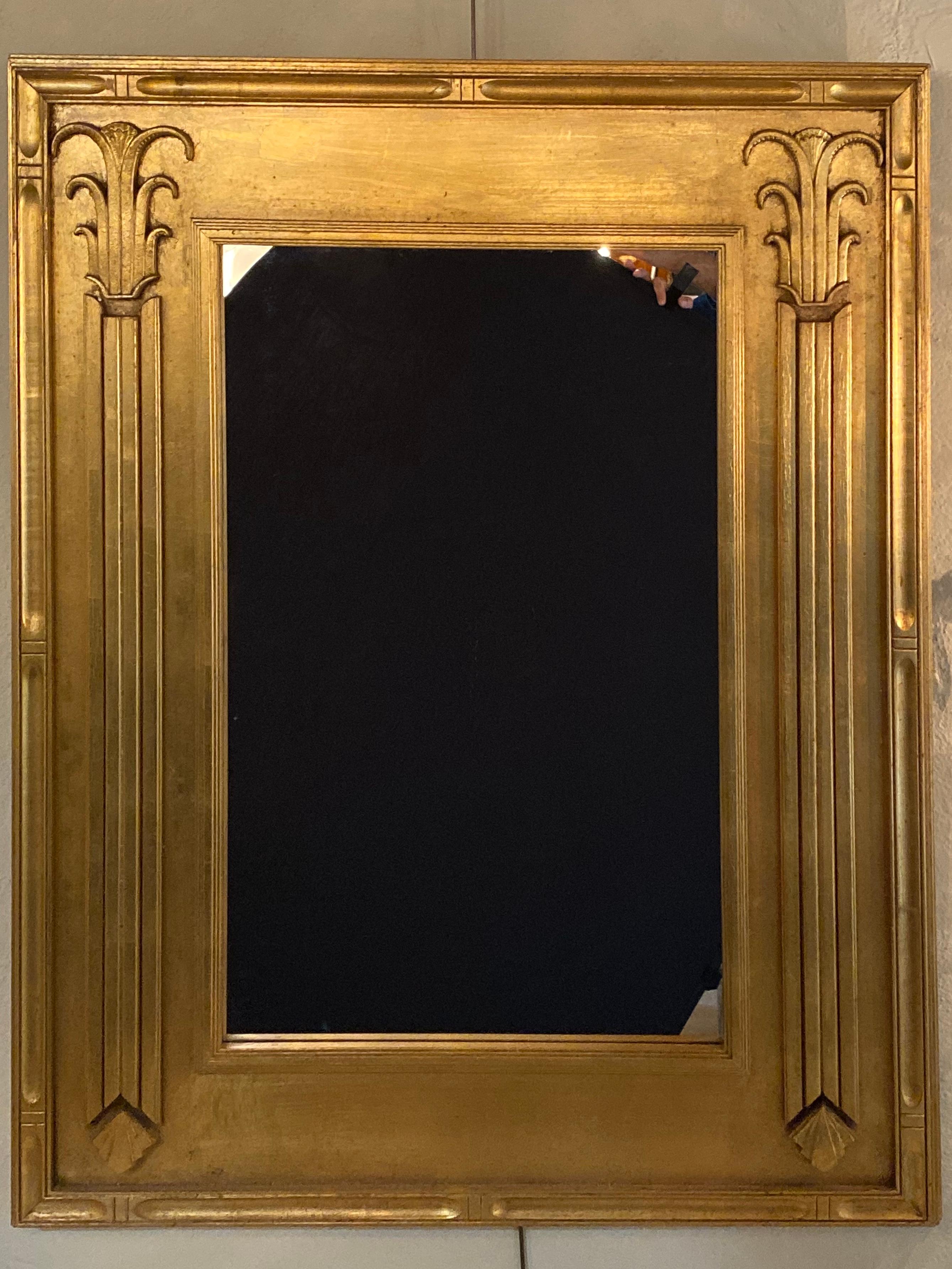 Pair of Art Deco style gilt gold architecturally carved wall or console mirrors. These solid giltwood wall, console or over the mantle mirrors are simply stunning with their sleek and stylishly carved architectural influenced frames. Having clean
