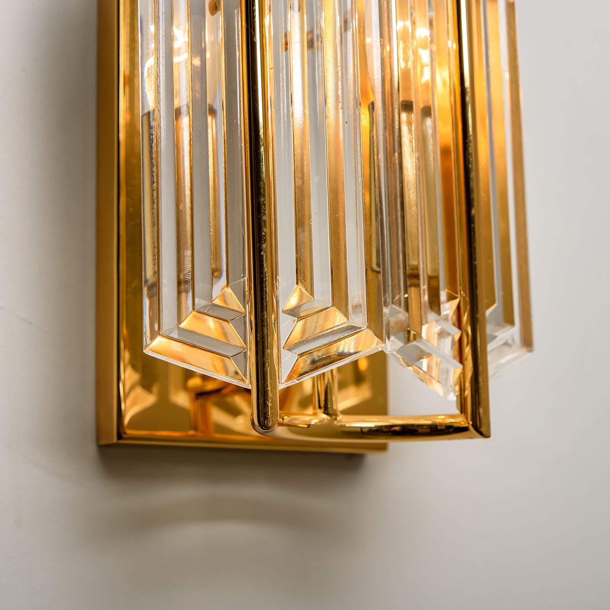 A pair of messing and molted glass wall lights from the 1960s. Each lamp has a beautiful stepped layers (Art Deco style) glass construction and a brass finish. High quality pieces. True craftsmanship of the 20th century.

The timeless elegance of