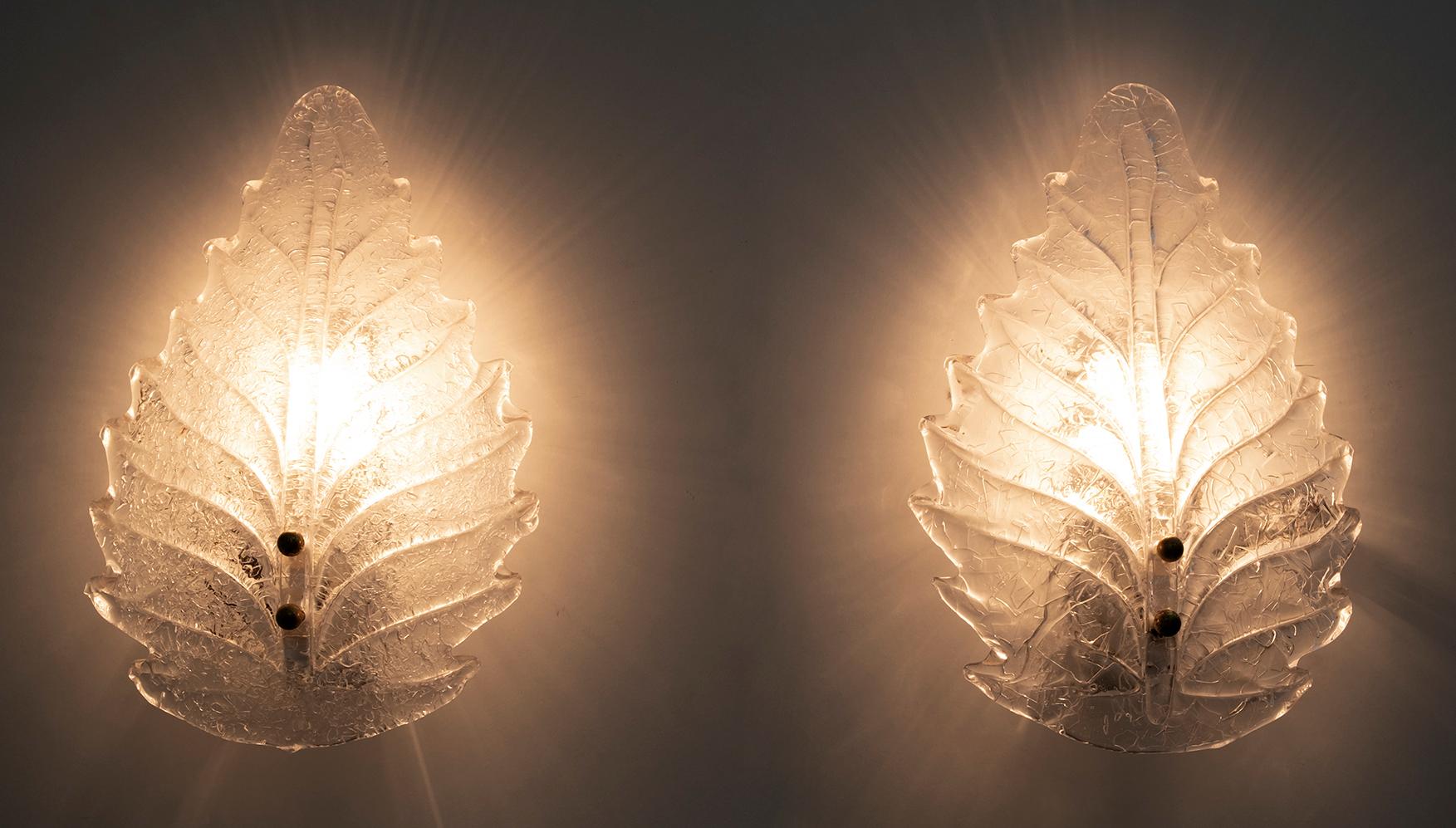 Pair of Italian Murano glass wall lights. Each wall lamp has a lacquered metal structure that supports a light bulb, shaded by a beautiful Murano glass Graniglia leaf. Production of the 1950s, in the style of Art Déco.