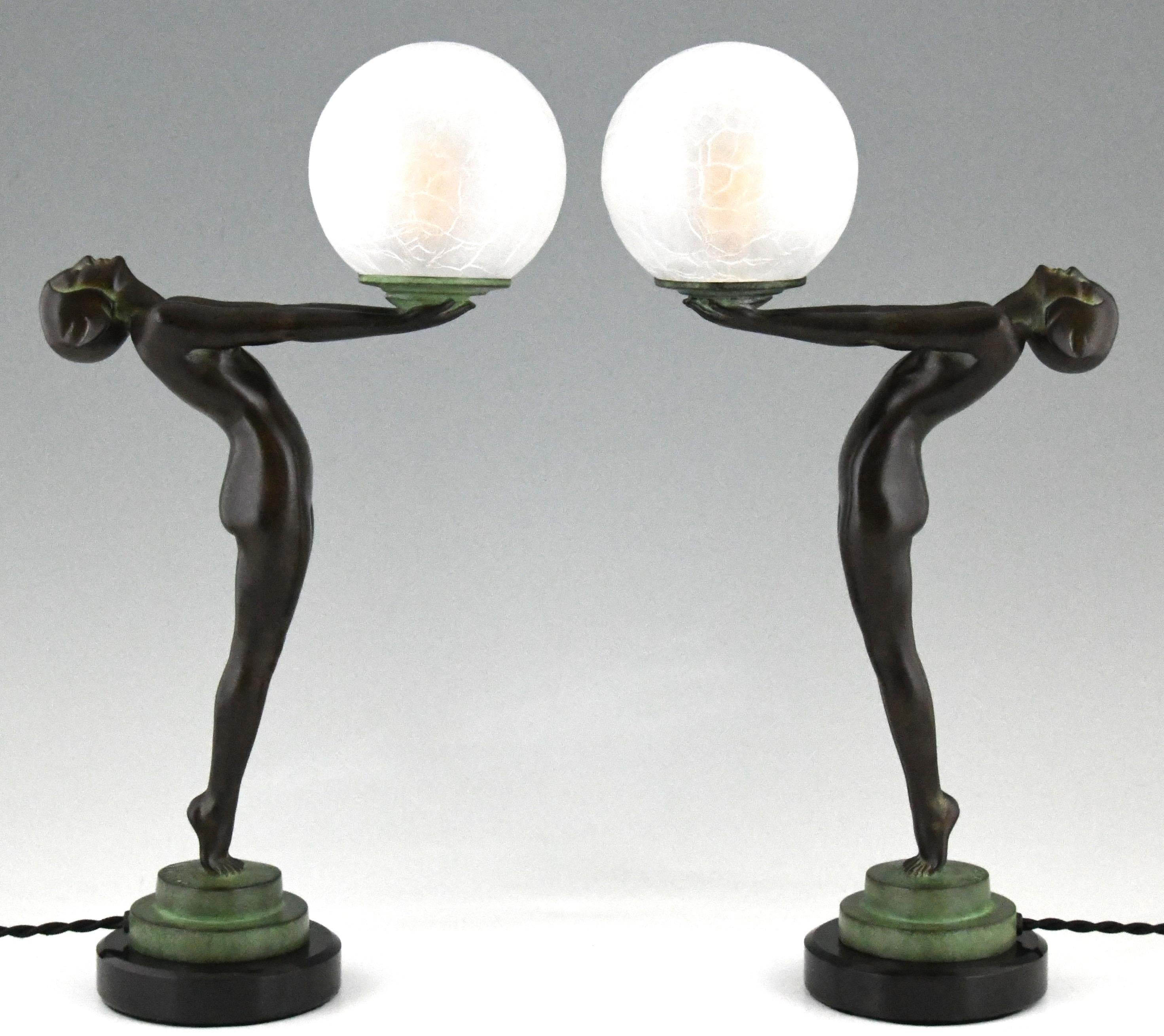 Pair of Art Deco style figural table lamps of a standing nude lady holding a glass globe.
This model is called Lueur lumineuse and is the smaller version of the iconic Clarté lamp by Max Le Verrier.
The lamps are signed and have the Le Verrier