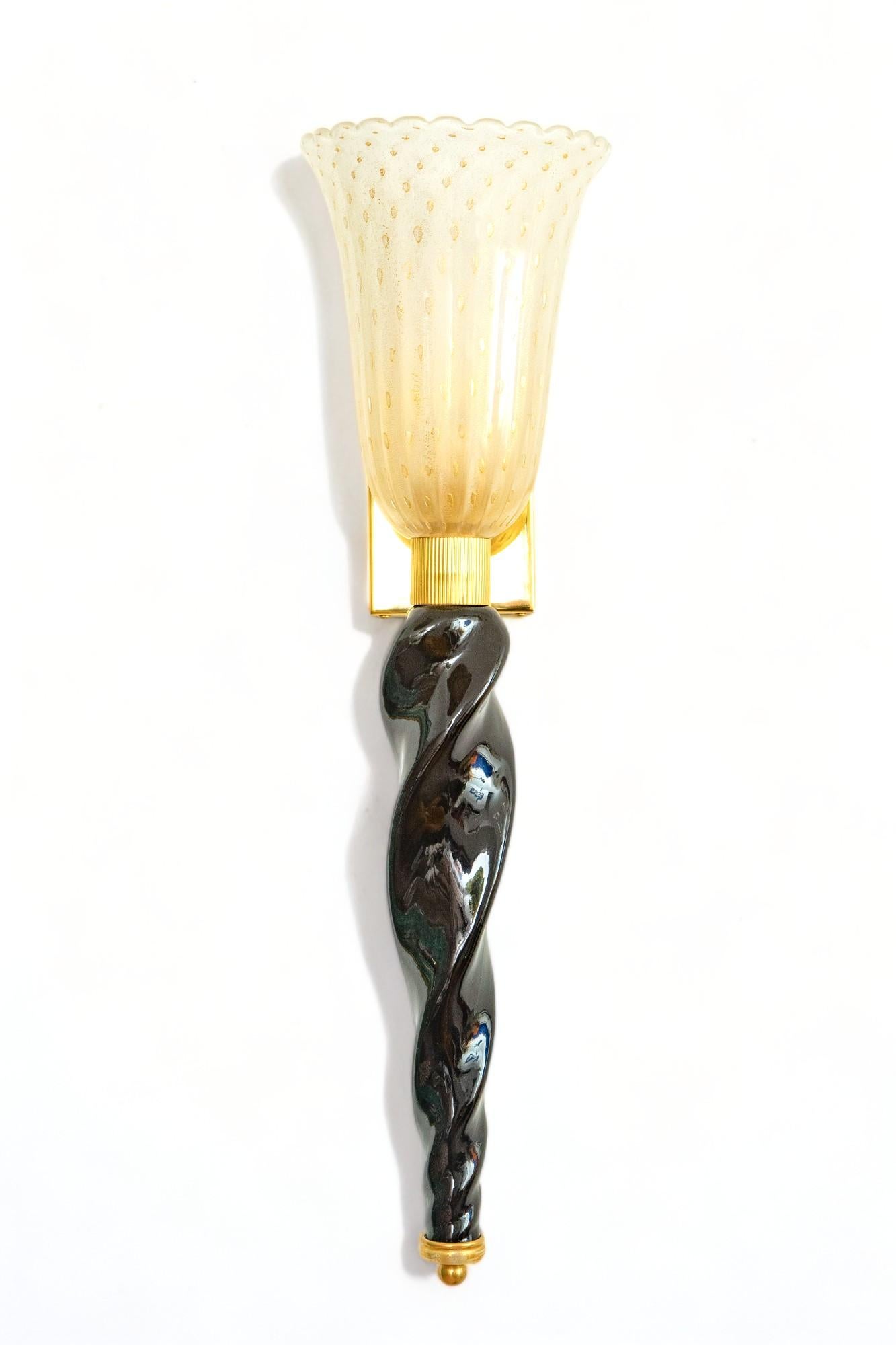 Pair of Art Deco style Murano black and gold glass wall lights torcheres,
 Hand blown frosted white Murano glass shades infused with gilded speckles, twisted black Murano glass stem, mounted on brass plated frame
Handcrafted by a team of artisans in