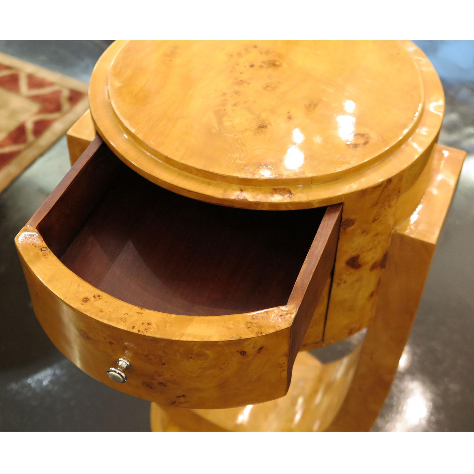 Pair of round nightstands in the style of Art Deco produced, circa 1960s. Crafted in Alder burl with curved facade and double drawers. A U-shaped base supports the rounded top.
Measures: 15.5