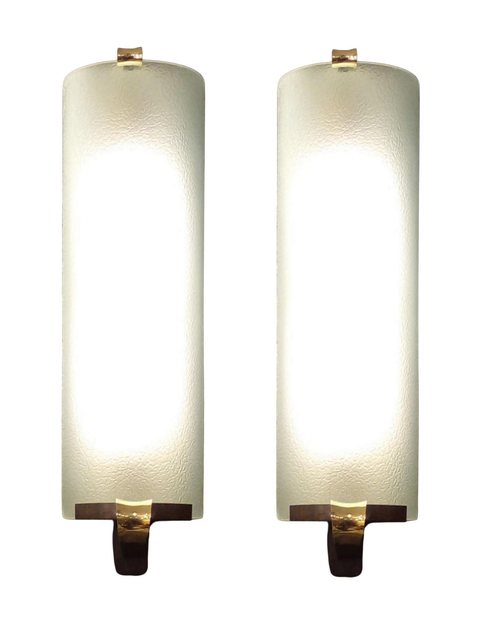 Paire d'appliques de style Art Déco composées d'un grand verre bombé et dépoli sur une structure en métal laqué. 
Les parties supérieure et inférieure qui maintiennent le verre sont patinées et dorées.  laiton.
deux ampoules électriques par