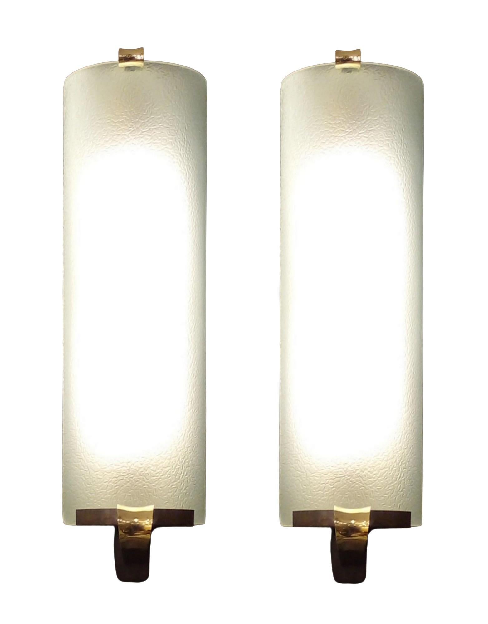 Pair of Art Deco style sconces composed of a large curved and frosted glass on a lacquered metal structure. 
The upper and lower parts that hold the glass are in patinated and gilded brass.
two electric bulbs per sconce. Very nice quality of