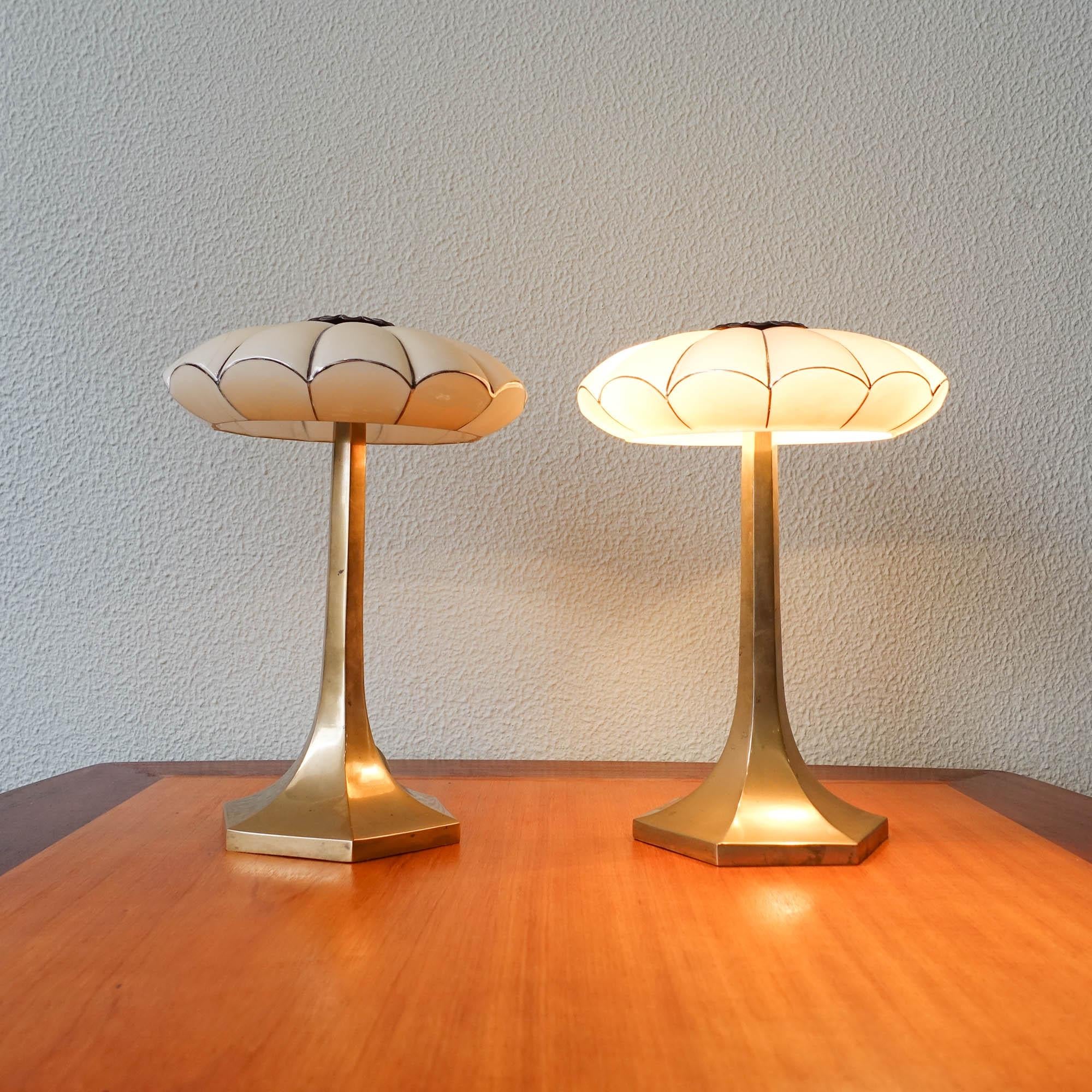 This pair of table lamps were designed by Josef Hoffman and produced by Wiener Werkstatte, in Austria, during the 1930's. Each lamp feature a solid brass hexagonal base were a delicate poly-lobed opaline glass is set. The glass is a light yellow