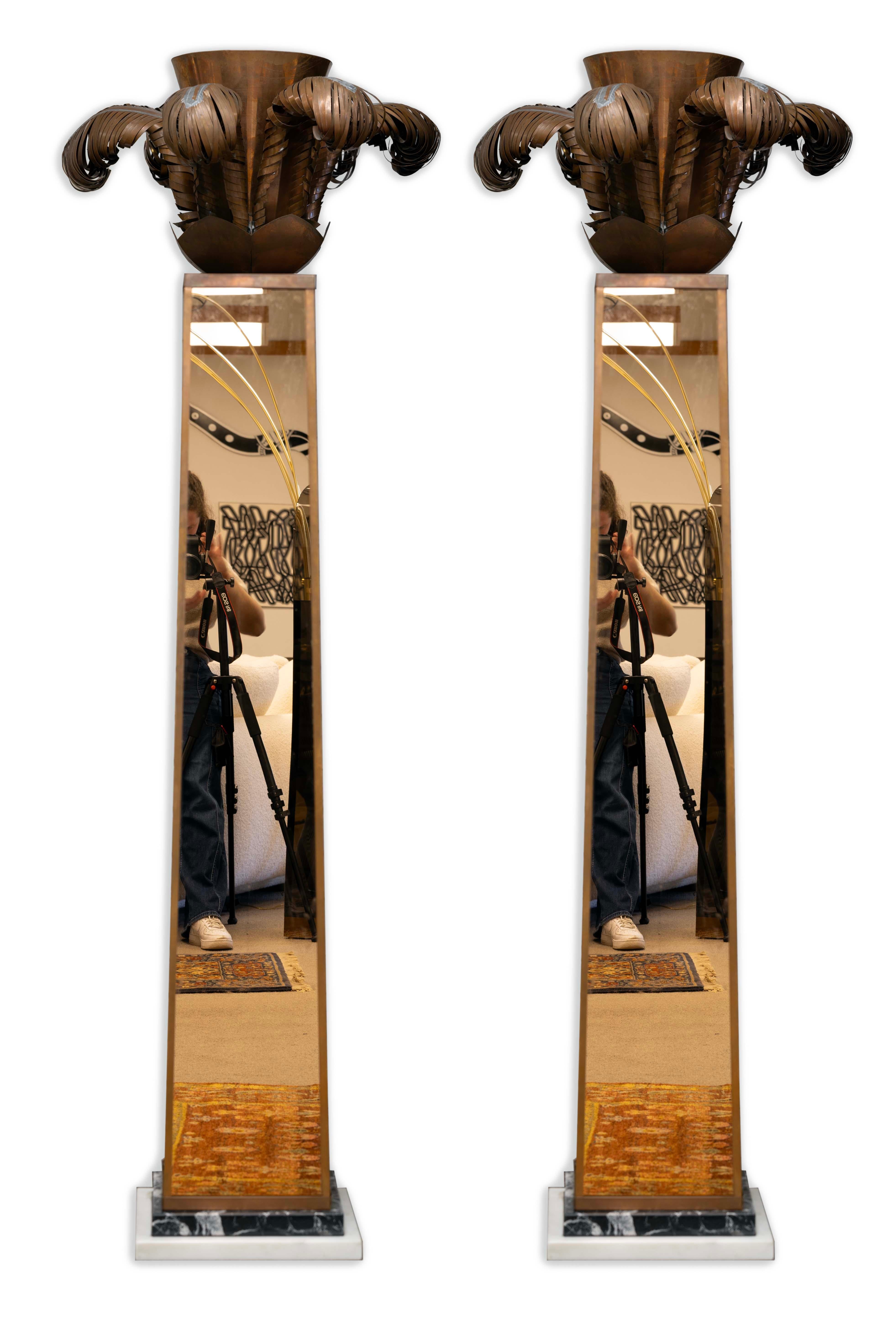 A Pair of Art Deco Torchiere Copper Mirrored Floor Lamps with Marble Bases; an iconic lighting experience for any art deco lover. With the copper palm tree style top, the mirrored copper, and black and white marble base, these torchiere floor lamps