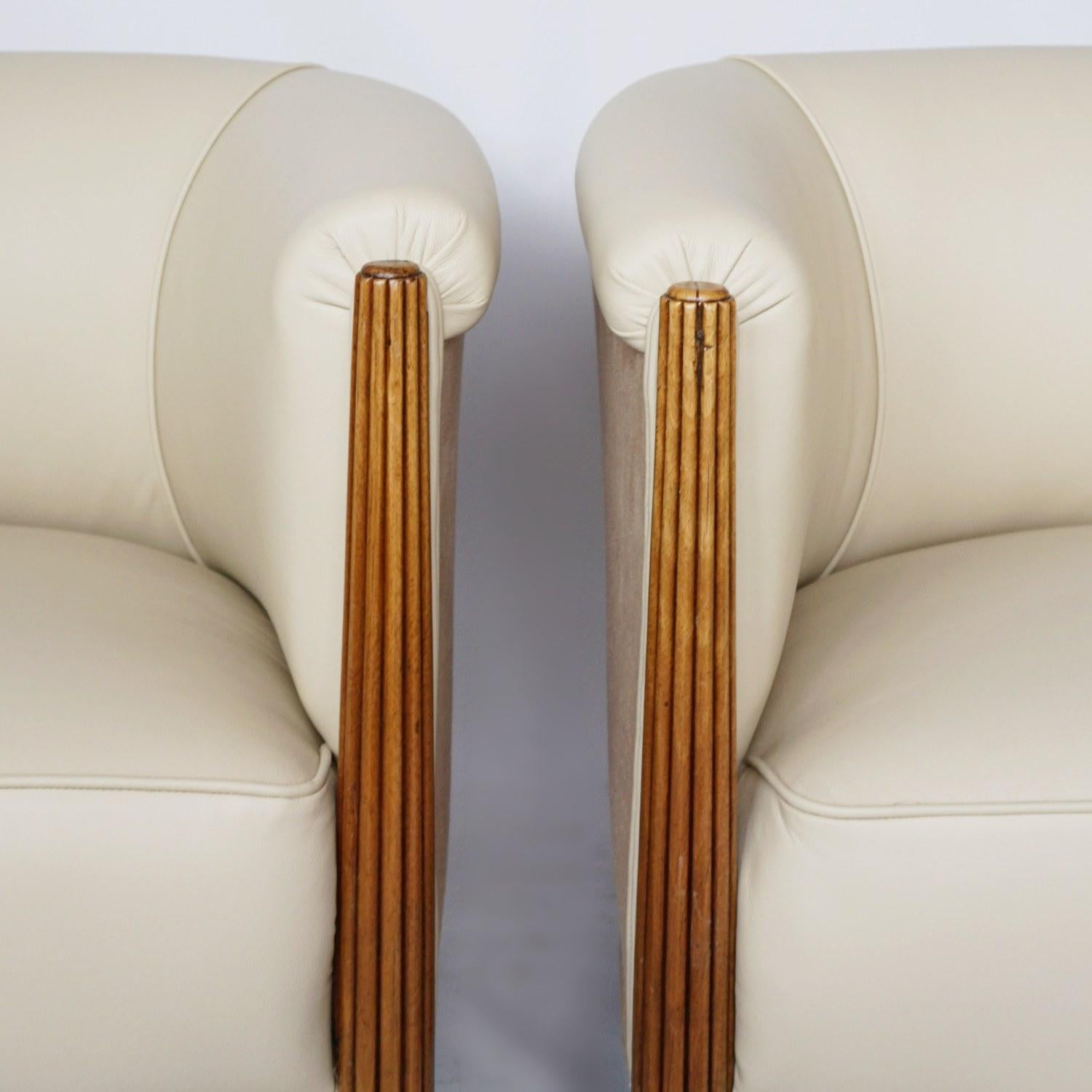 A pair of Art Deco tub chairs attributed to Paul Follot. Reeded solid walnut arms, with solid beech back legs. Re-upholstered in cream leather and faux suede. 

Dimensions: H 62cm, W 70cm, D 53cm, seat H 39cm, W 48cm, D 45cm

Origin: