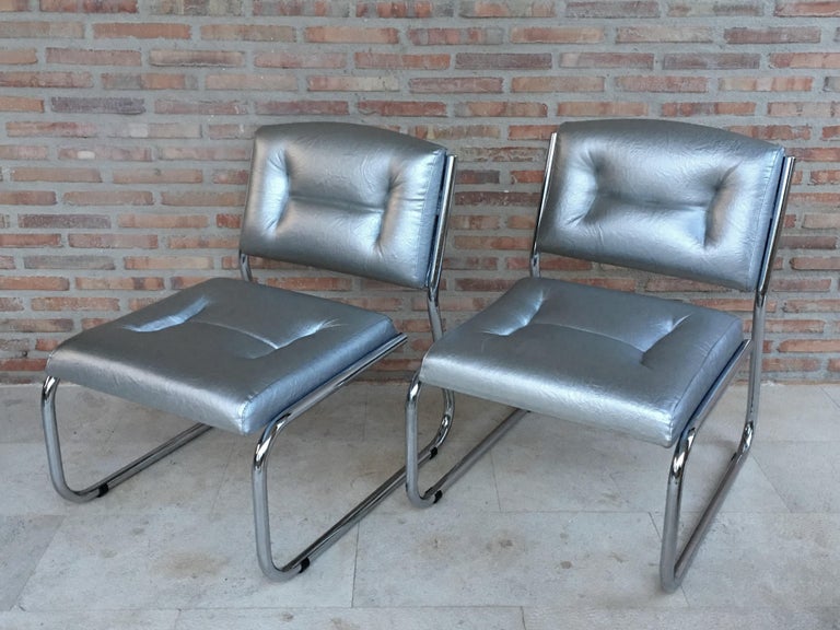 Mid-Century Modern pair of Art Deco tubular chrome lounge chairs in black leather.