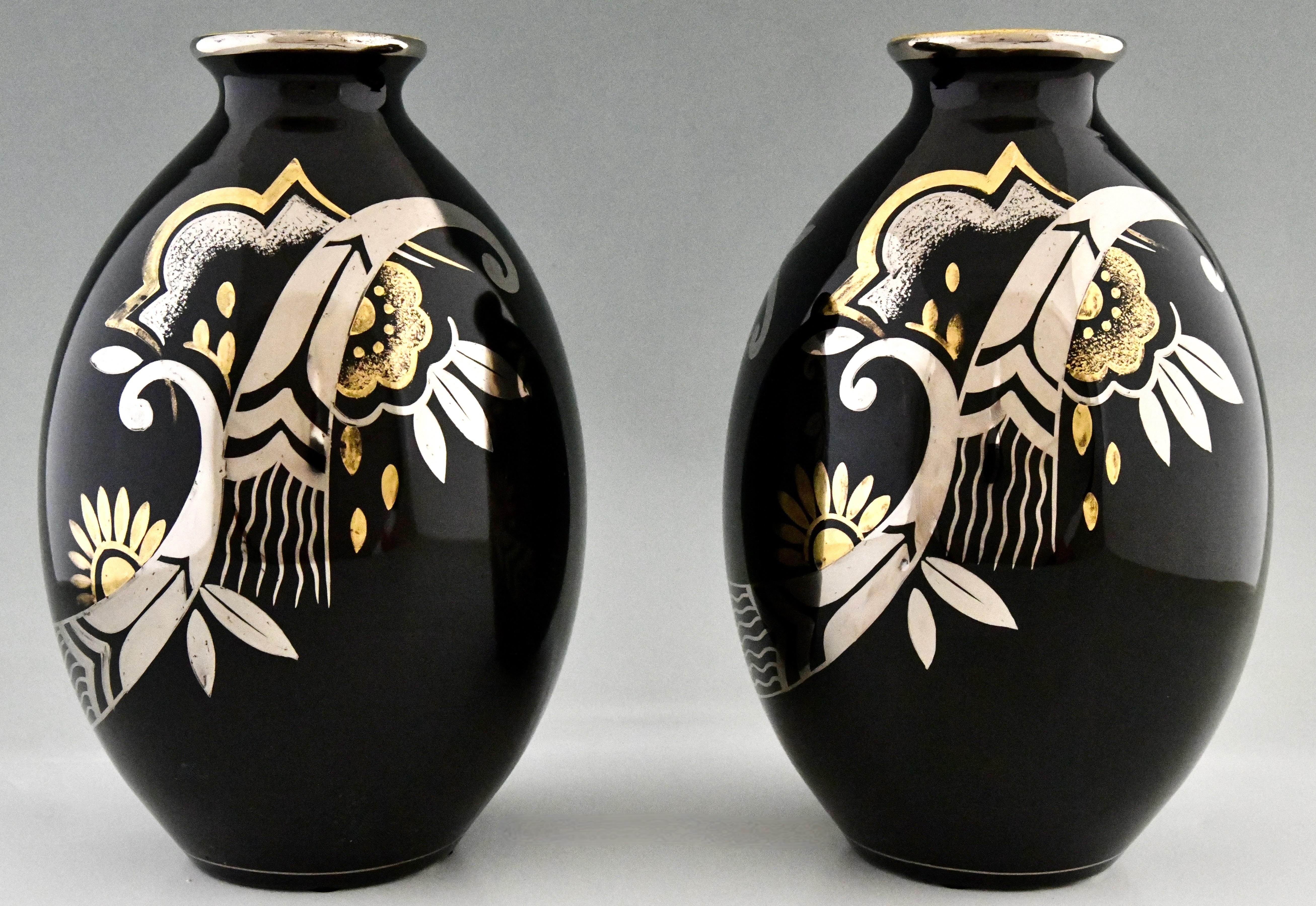 Pair of Art Deco vases with flowers and Art Deco pattern in silver and gold on a black shiny glaze by Boch Frères, La Louvière. 
With Boch Frères stamp. Model number D 1780.
Belgium, 1931/1932.
Literature:
L'homme de Keramis Charles Catteau,