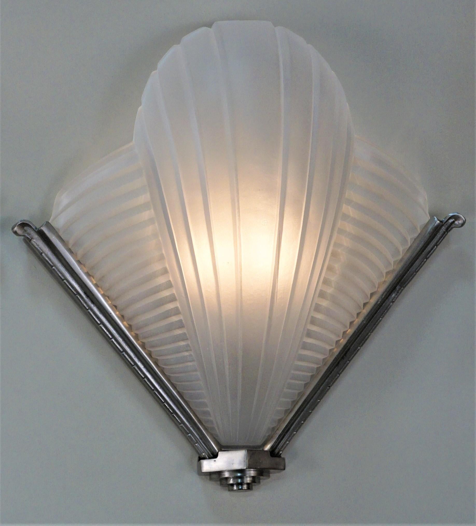 Pair of stream·line line design but very elegant double light wall sconces with nickel on bronze framing.