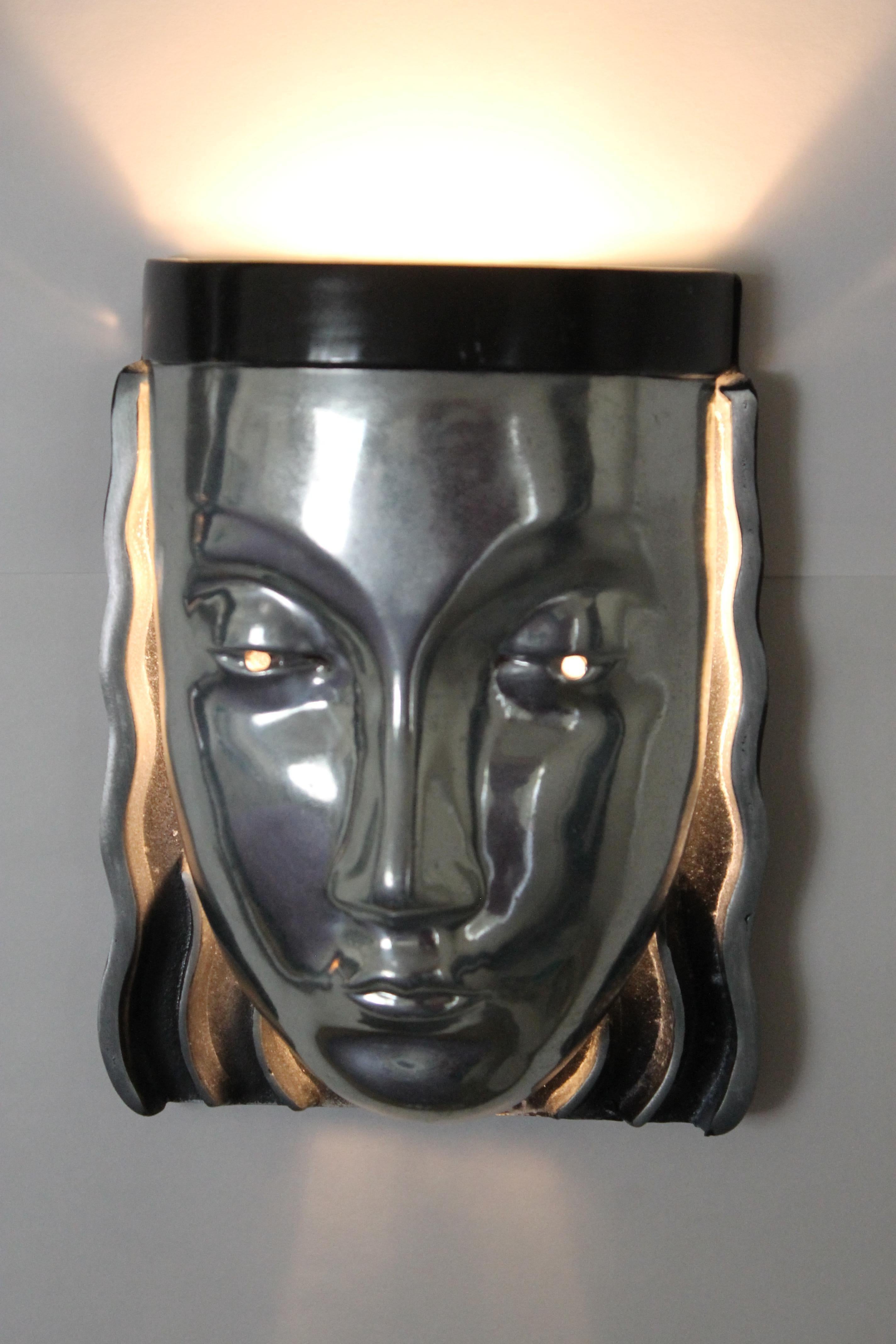 A pair of cast aluminum Art Deco style face sconces by Sarsaparilla Company, circa 1982. Light shines mainly upwards but also downwards through the hair. Great dramatic affect. Matched pair, excellent working condition measuring 6