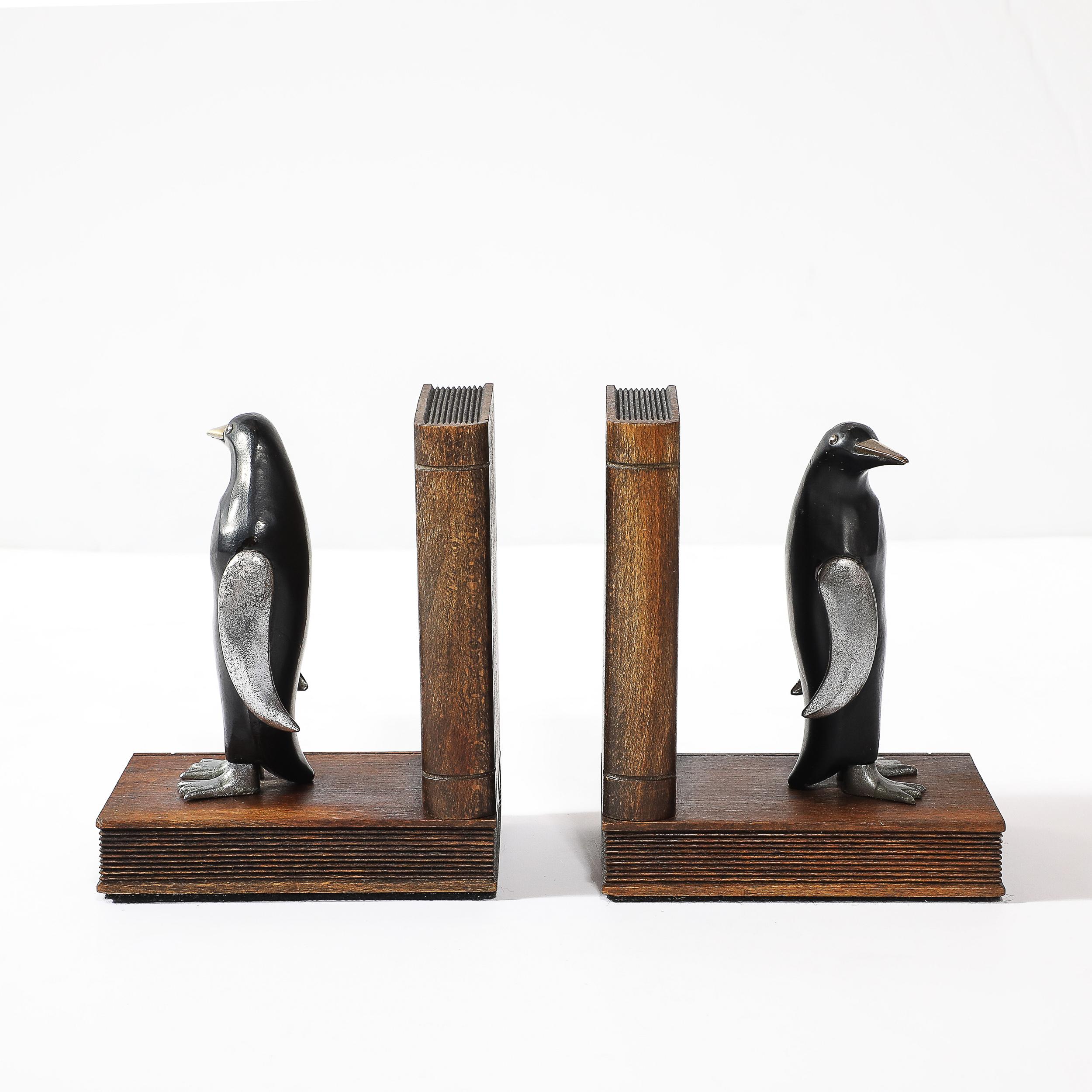 This charming pair of Art Deco sculptural bookends features a playful and elegant penguin design, showcasing the sophisticated craftsmanship of American artisans circa 1935. The bookends are crafted from warm walnut, highlighting the beauty of