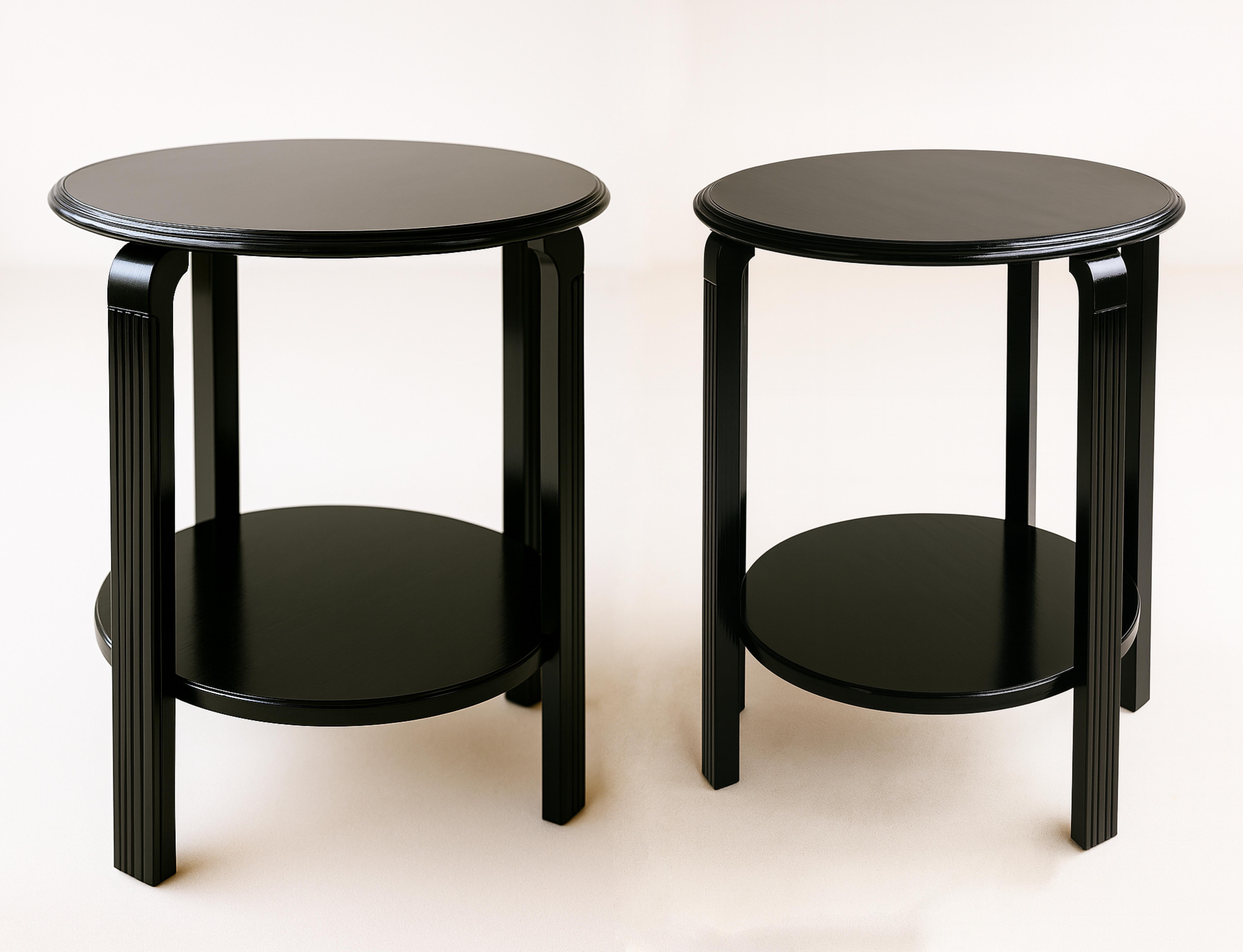 Una coppia di tavolini Art Decor in lacca nera con finitura a vernice, ideali per qualsiasi tipo di arredamento.