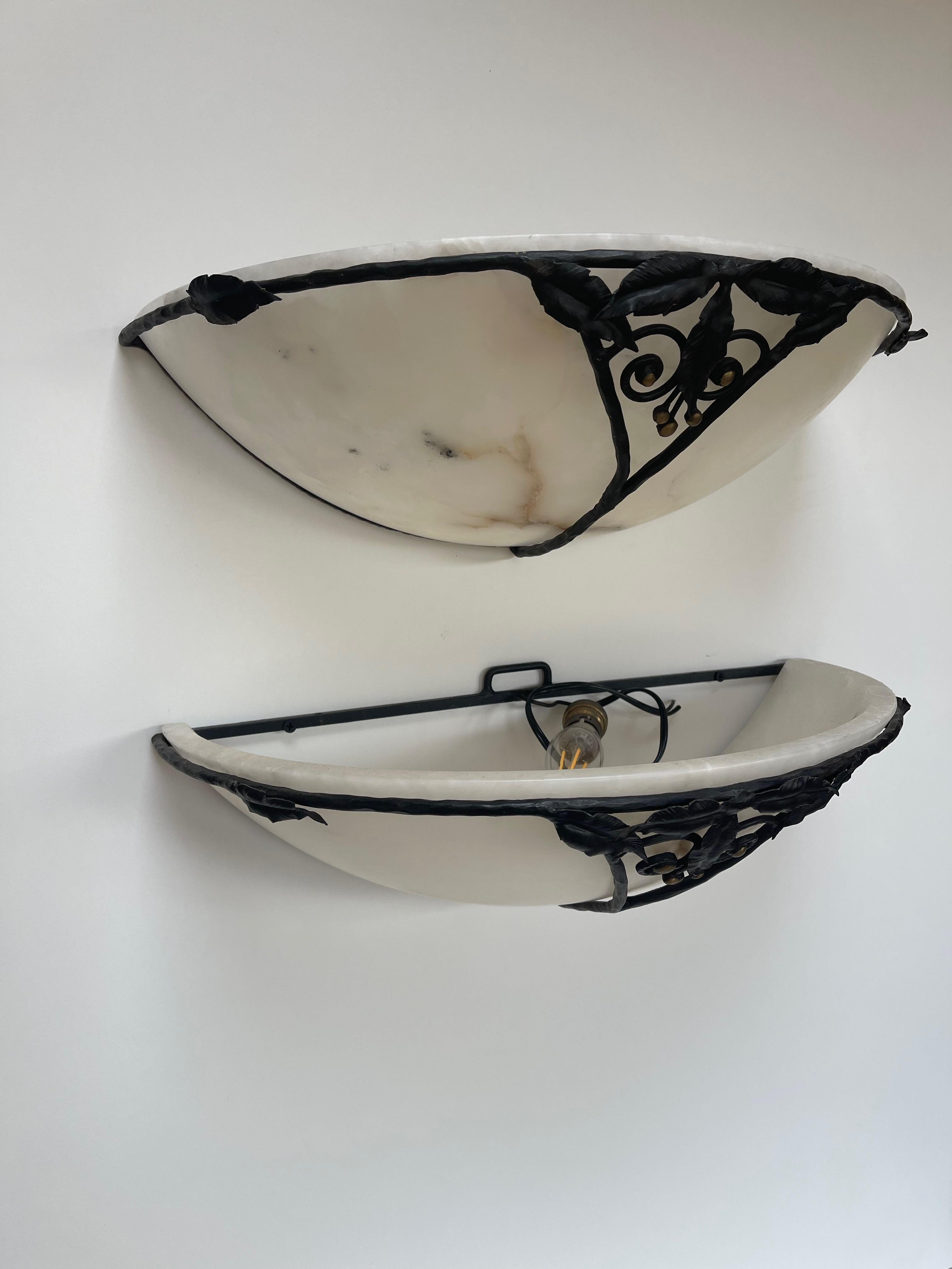 Pair of 1930 wall lights, large size.
Wrought iron frame decorated with leaves.
Alabaster cup.
In very good condition and electrified.
Measures: width: 47cm
height: 13cm
depth: 24.5cm
Weight: 8 Kg