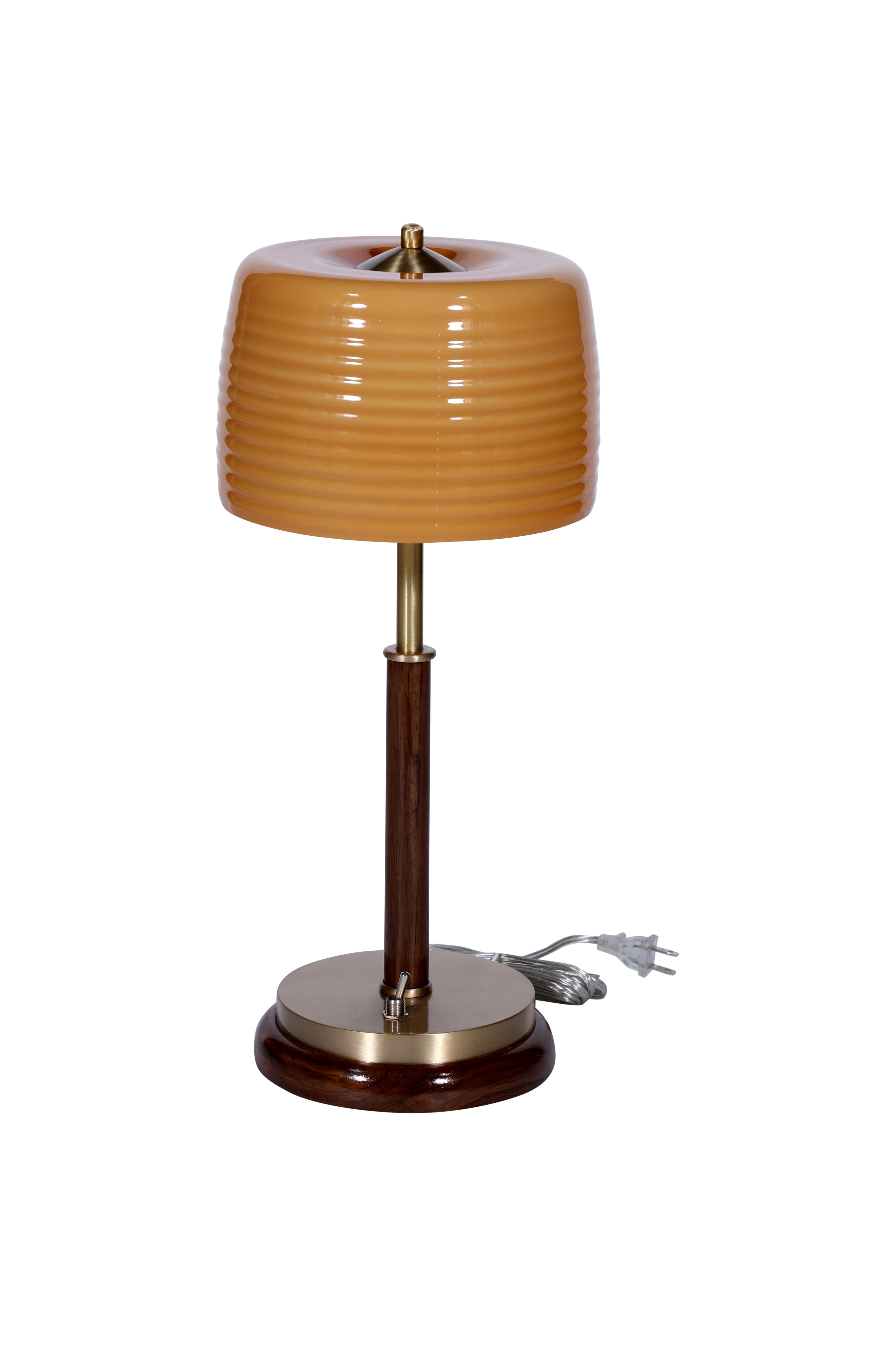 A beautiful caramel-colored pair of art glass, ribbed shades from Europe.  Mounted on teak and brass table lamp bases.  Rewired for American use and takes two E-14 European base bulbs (easy to get).

The Lockhart Collection is a personally curated