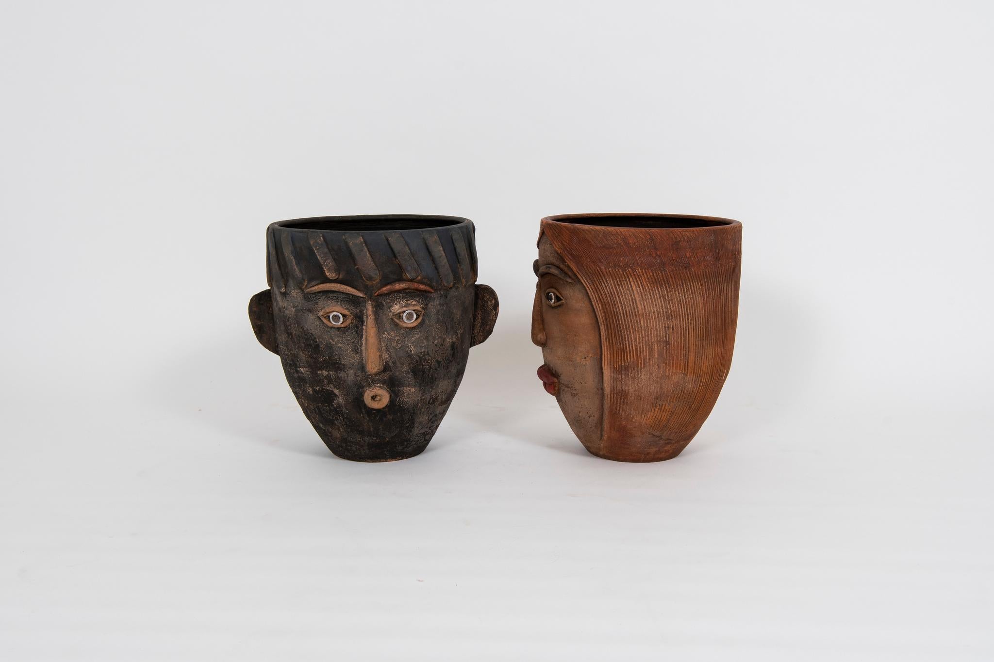 Pair of 1960s art terra cotta face planters, one male head showing ears and one female head.

Dimensions:
Male 18