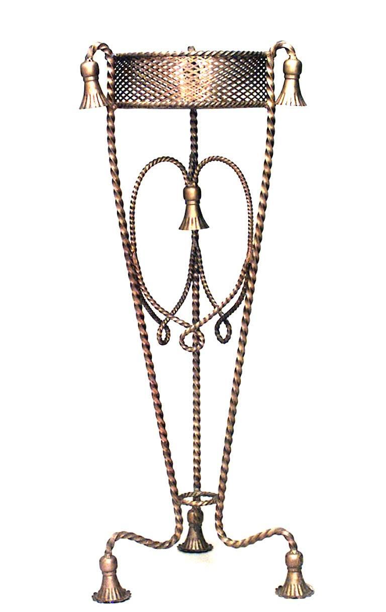 Paire de piédestaux en métal doré à trois pieds en forme de fougère ou de jardinière, avec plateau rond en maille (20e siècle), à décor de cordes et de glands.
 