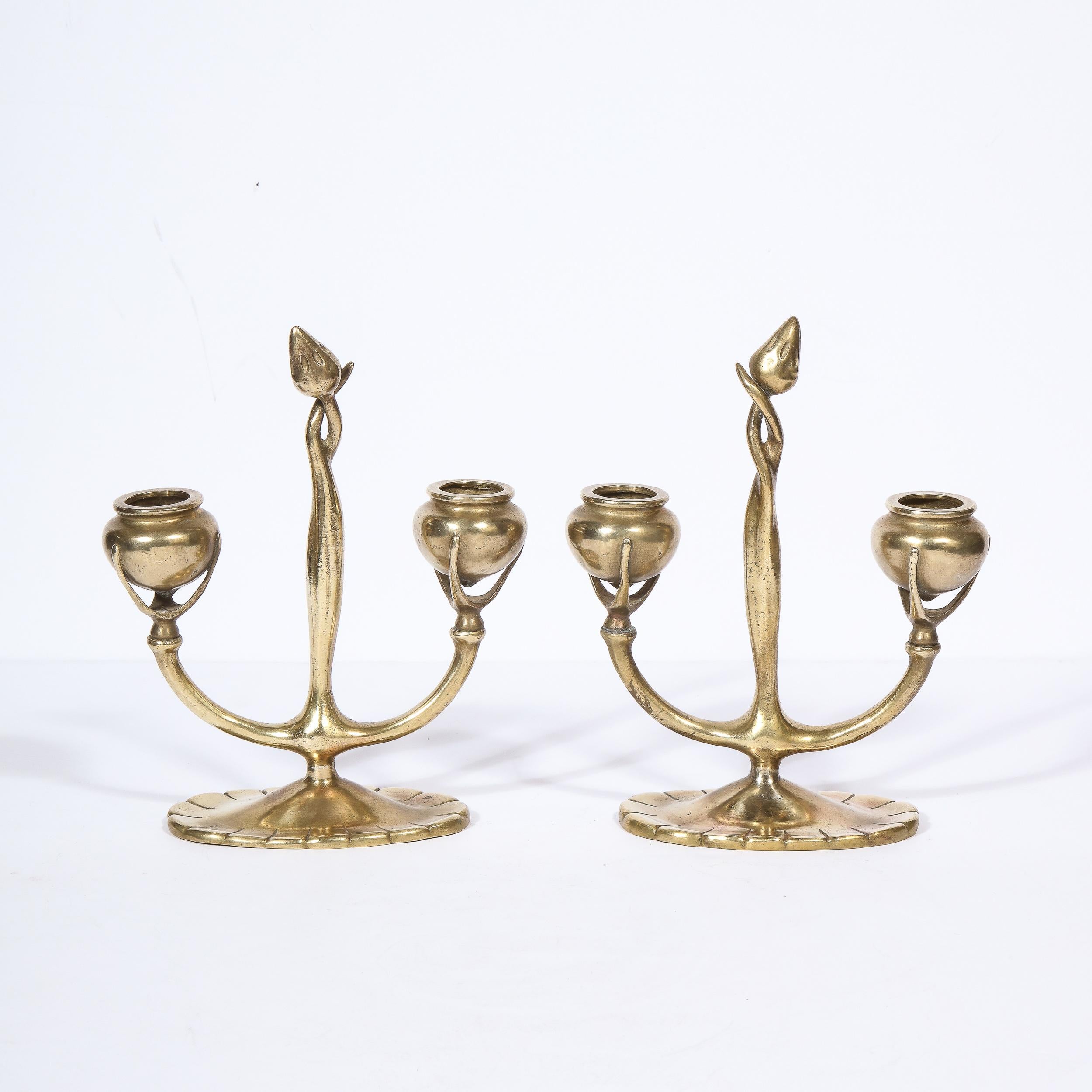 This stunning pair of bronze Art Nouveau candelabras were realized in the United States circa 1910 by Tiffany Studios- one of America's finest luxury goods companies since 1837. They feature graphic and sculptural forms consisting of two urn form