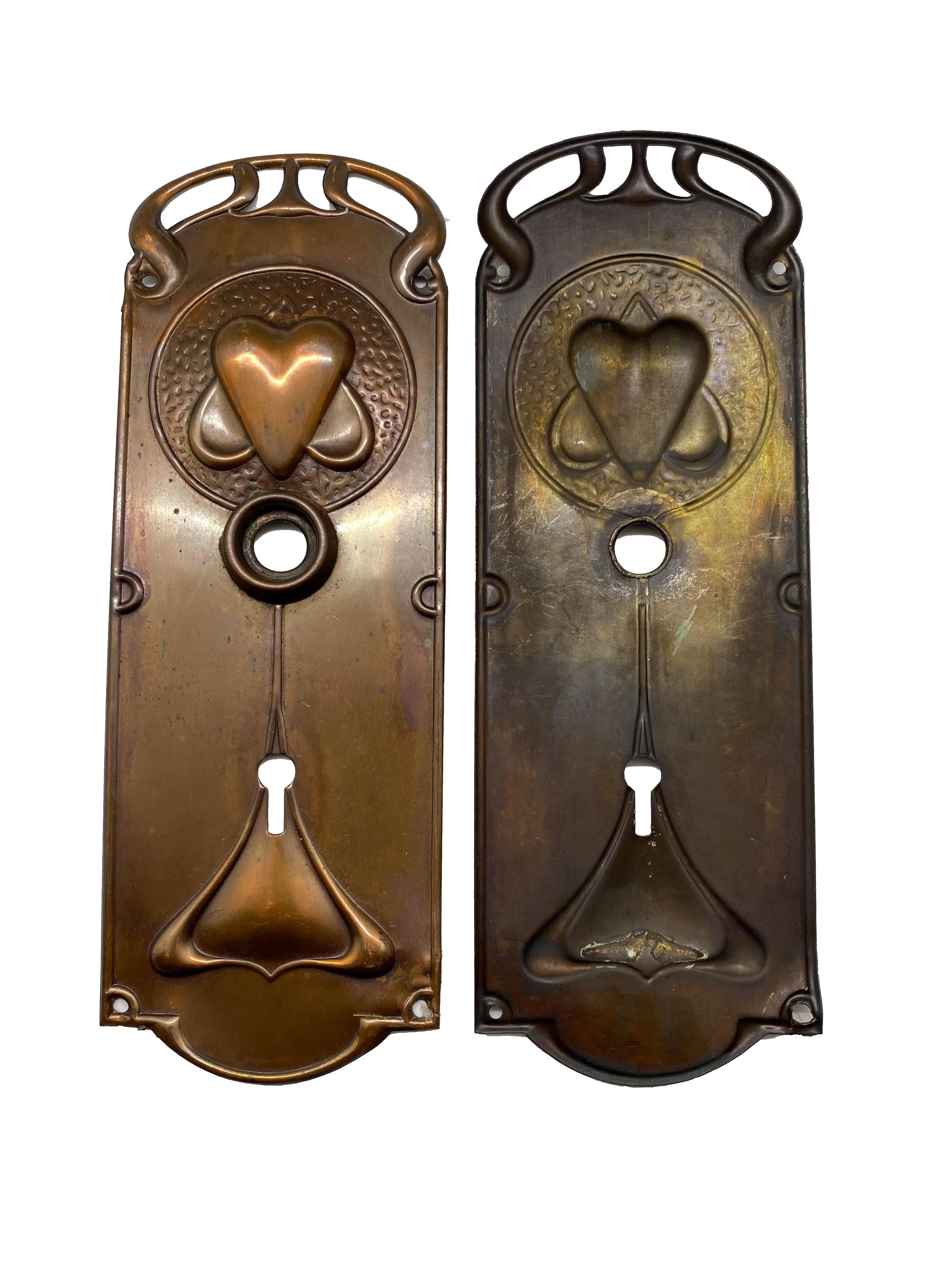 Pair of original Art Nouveau copper doorknobs and doorplates. Set includes 15 pieces: two knobs, two doorplates, a mortise lock, a strike plate, a spindle with two set screws, and six screws.