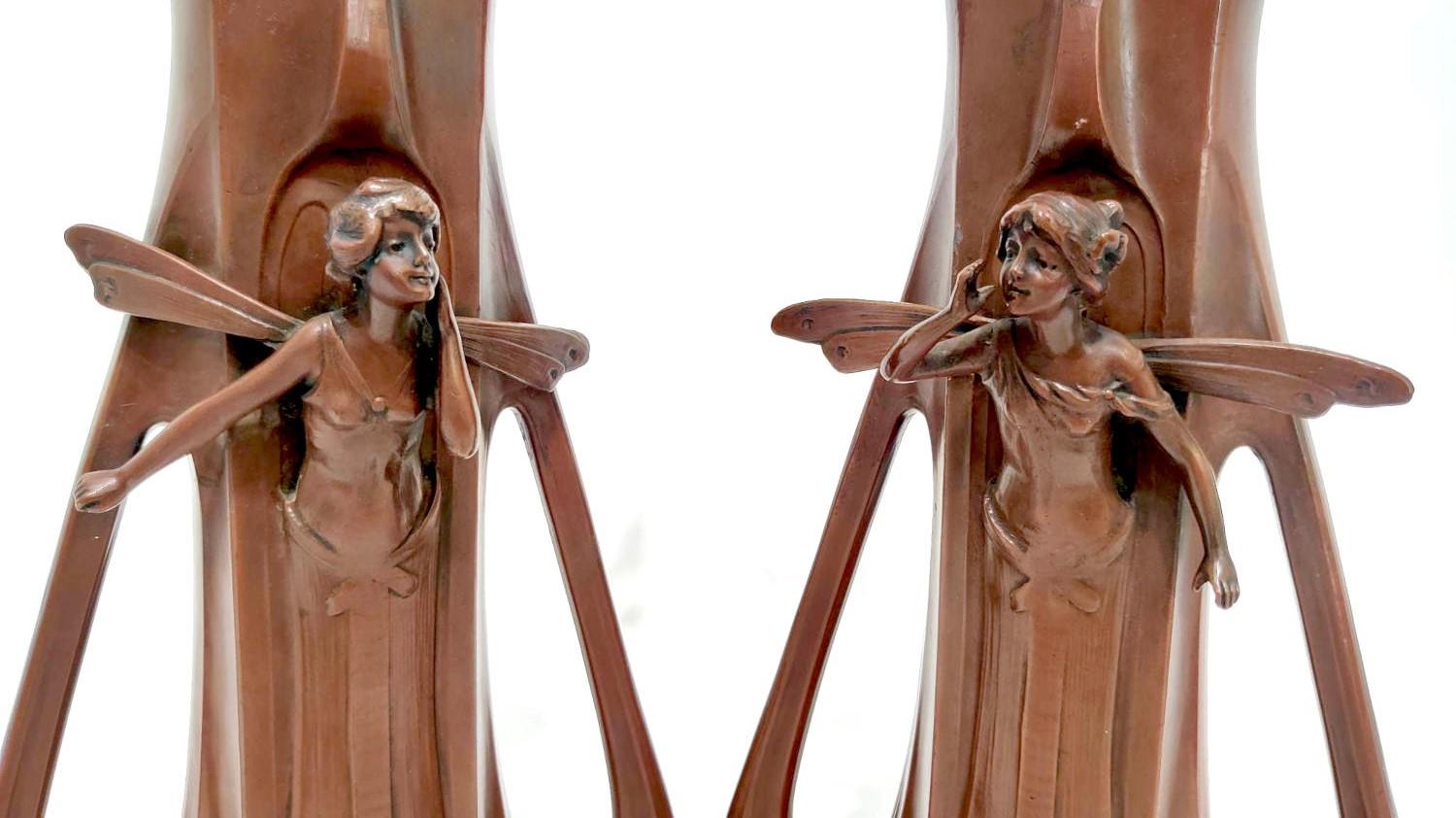 Charmante paire de vases Art nouveau représentant un couple de fées. L'une des fées appelle son partenaire, qui l'écoute depuis l'autre vase. Le dos des vases est orné d'une marguerite. Les vases présentent d'élégantes lignes et poignées art