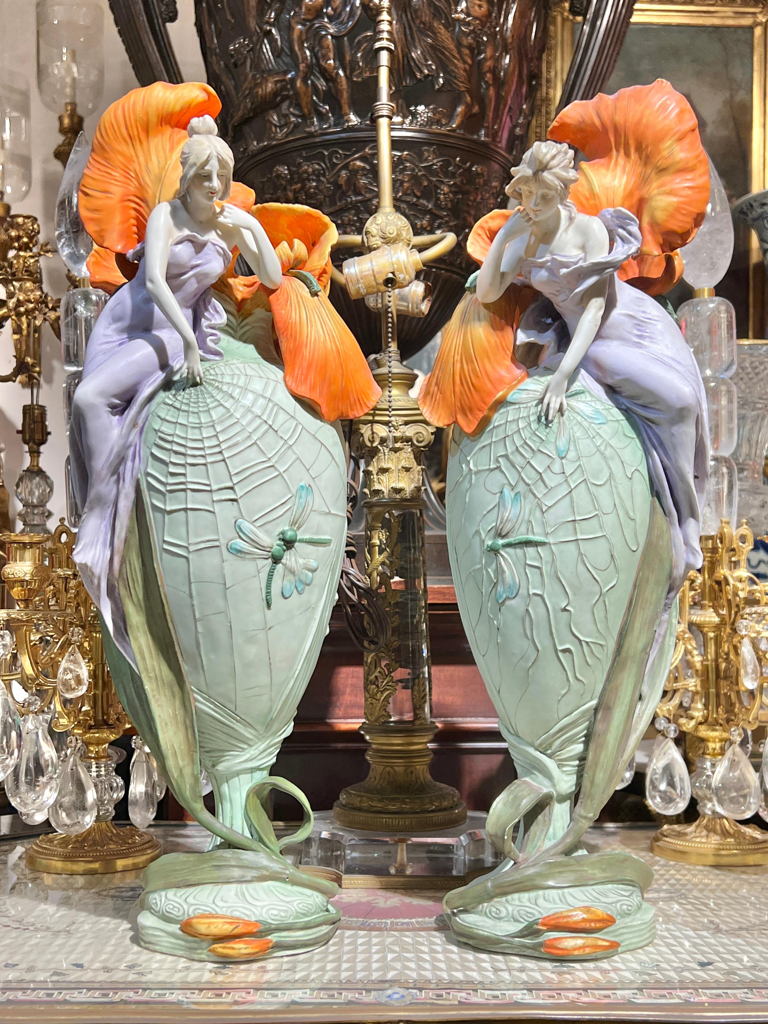 Lovely pair of antique (early 20th century) polychrome glazed flower vases distinguished by their finely modeled female figures, by Amphora, the firm based in Turn-Teplitz, present-day Austria.  Each in excellent condition.