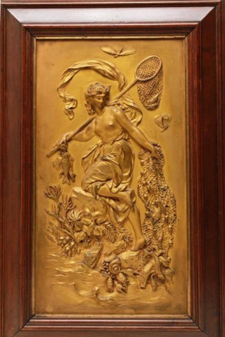 Art Nouveau gilt bronze plaques with high-relief classical themes, depicting Diana the huntress in pursuit of a stag, and Amphitrite, wife of Neptune, with fishing nets, seaweed, a crocodile, and seashells, both stamped lower right corner 