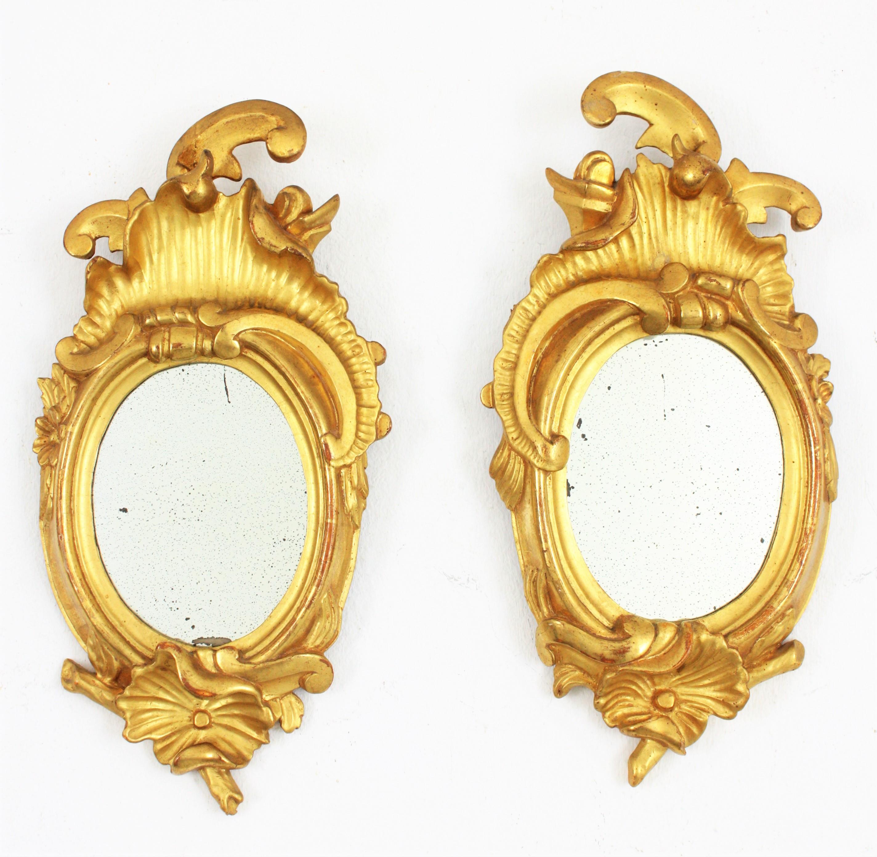 Pair of Art Nouveau Left and Right Gold Leaf Giltwood Mini Sized Mirrors
Exquisite and richly carved pair of left and right petite mirrors. Carved wood, covered with gesso and 24-karat gold leaf finishing. 
These small sized Art Nouveau carved