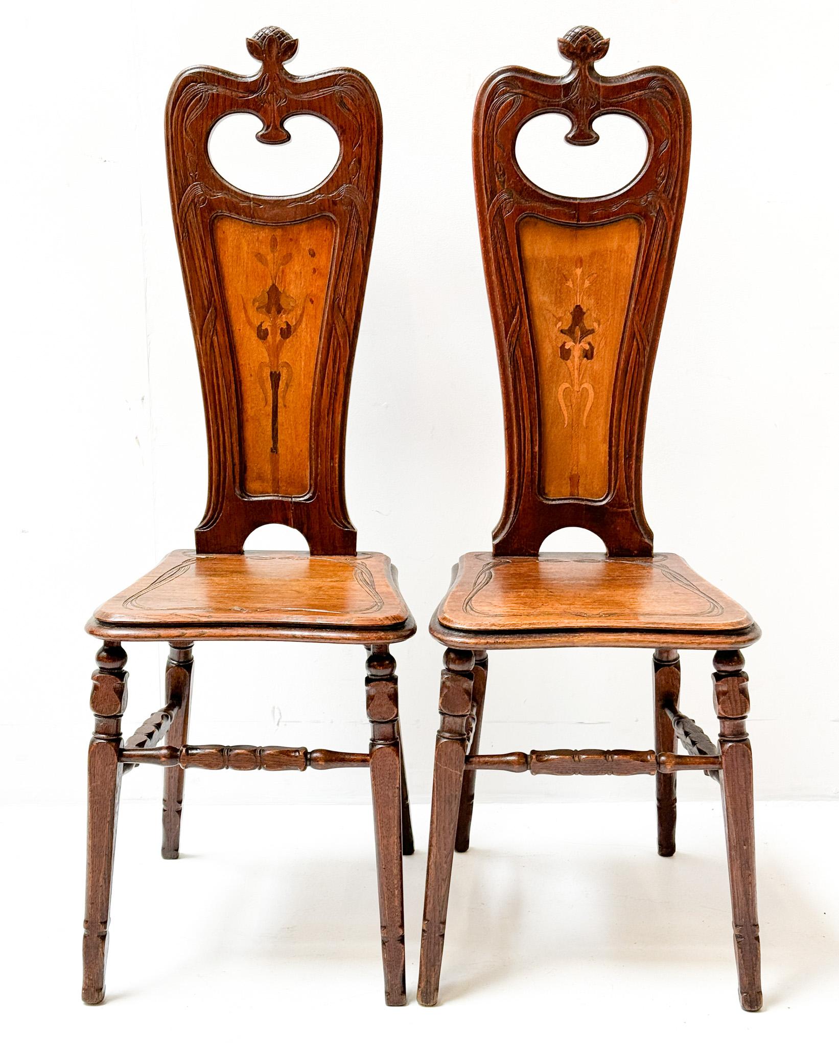 Magnificent and rare pair of Art Nouveau side chairs.
Design by Emile Gallé.
Striking French design from the 1890s.
Solid oak frames with original sycamore decorations of flowers in the backsides.
This wonderful pair of Art Nouveau side chairs by
