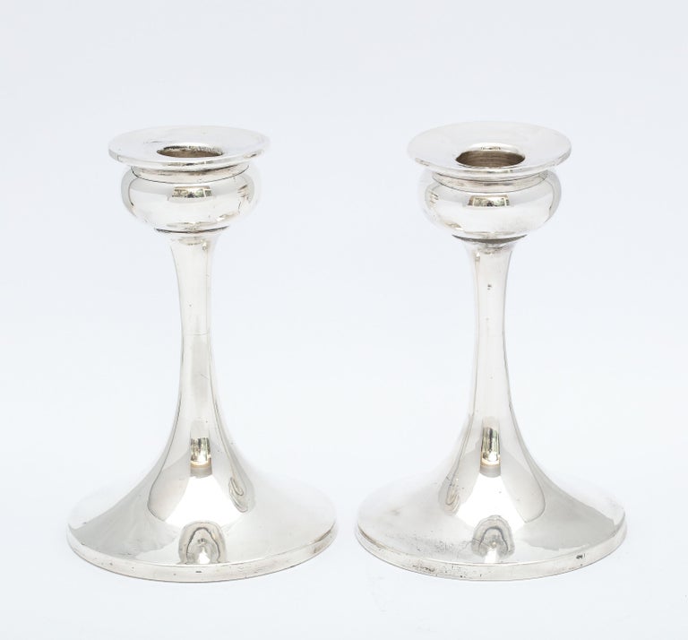 Pair of sterling Silver Art Nouveau candlesticks, Birmingham, England, year-hallmarked for 1921. Maker's mark rubbed. Each candlestick measures 5 1/2 inches high x 3 3/4 inches diameter across base. Graceful design. Weighted. wooden underside. There