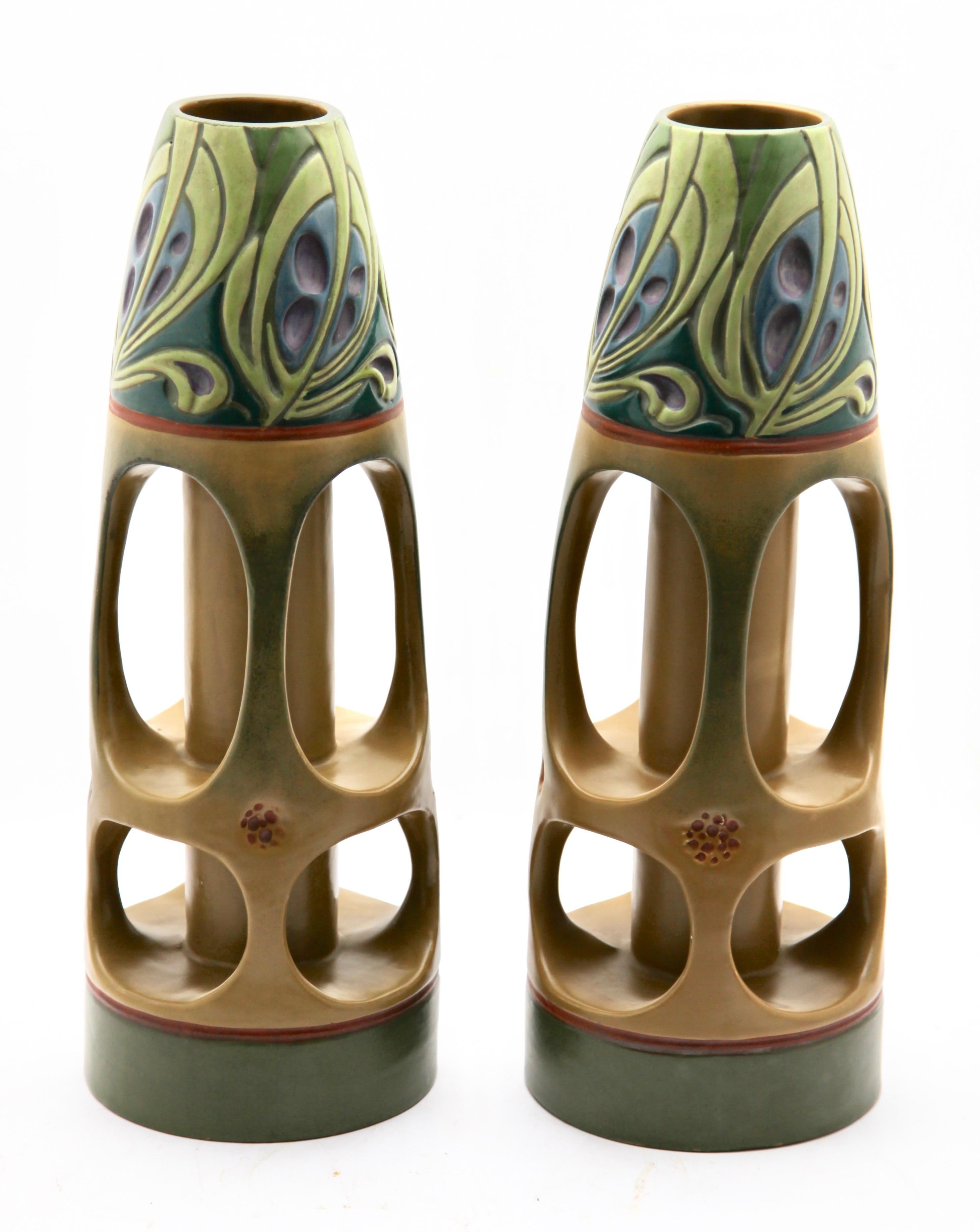 An eye-catching and unusual matching pair of Art Nouveau vases. Made in Vienna in the first flush of Julius Dressler's breakthrough. 
These earthenware vases have blue and green enamel glazes illustrating foliage in Art Nouveau style, presented on