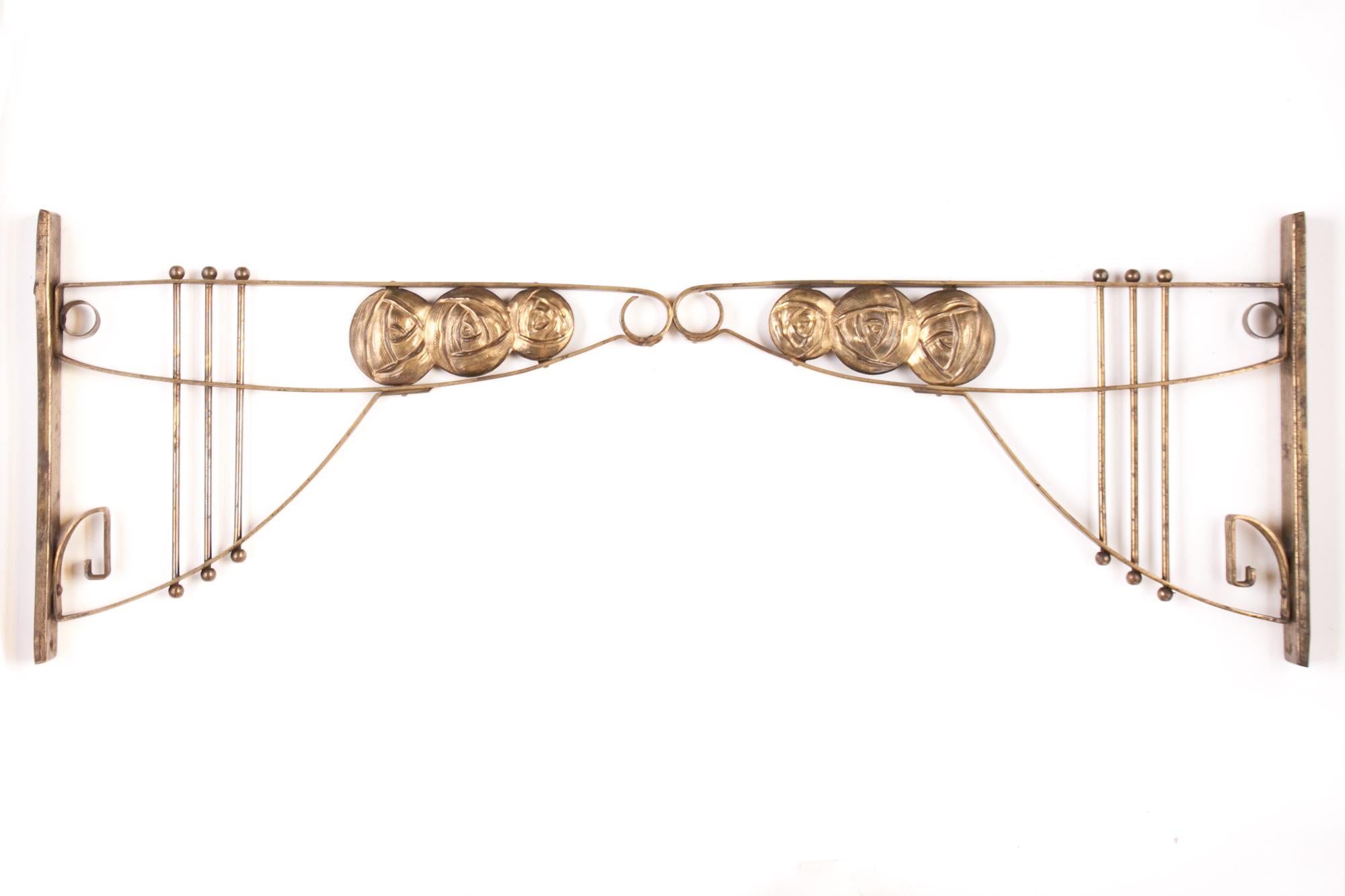 Elegant pair of brackets for wall mounting, with decorative elements in the style of the well-known Vienna Secession period, from the 1910s. They are made of brass, according to a traditional handicraft technique. The pair of brackets can ideally be