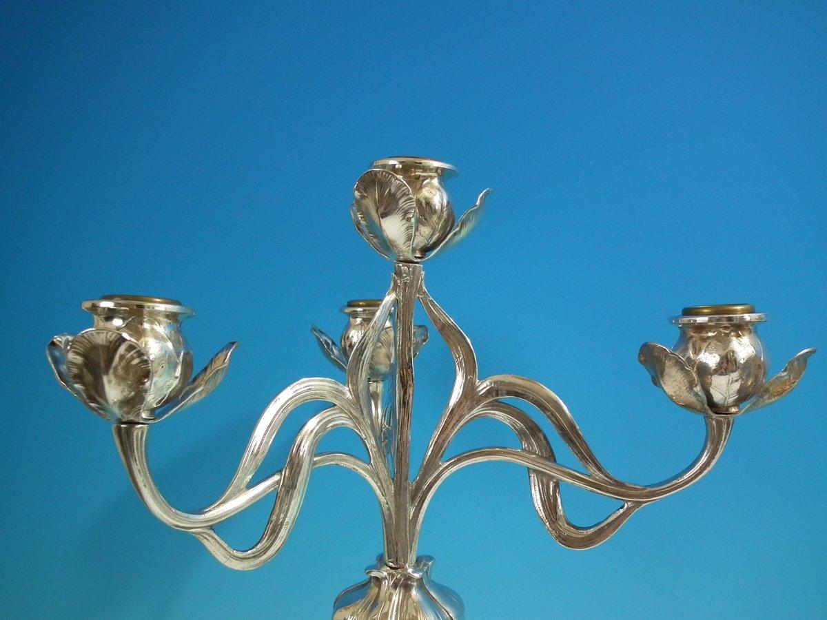 Pair of Art Nouveau WMF 4-branch candelabra, modelled as a maiden holding aloft a flower. Tendrils sprout from the flower, terminating in four foliate sconces. The maiden's flowing dress forms the base. Seven removable sconce cups. Maker's marks to