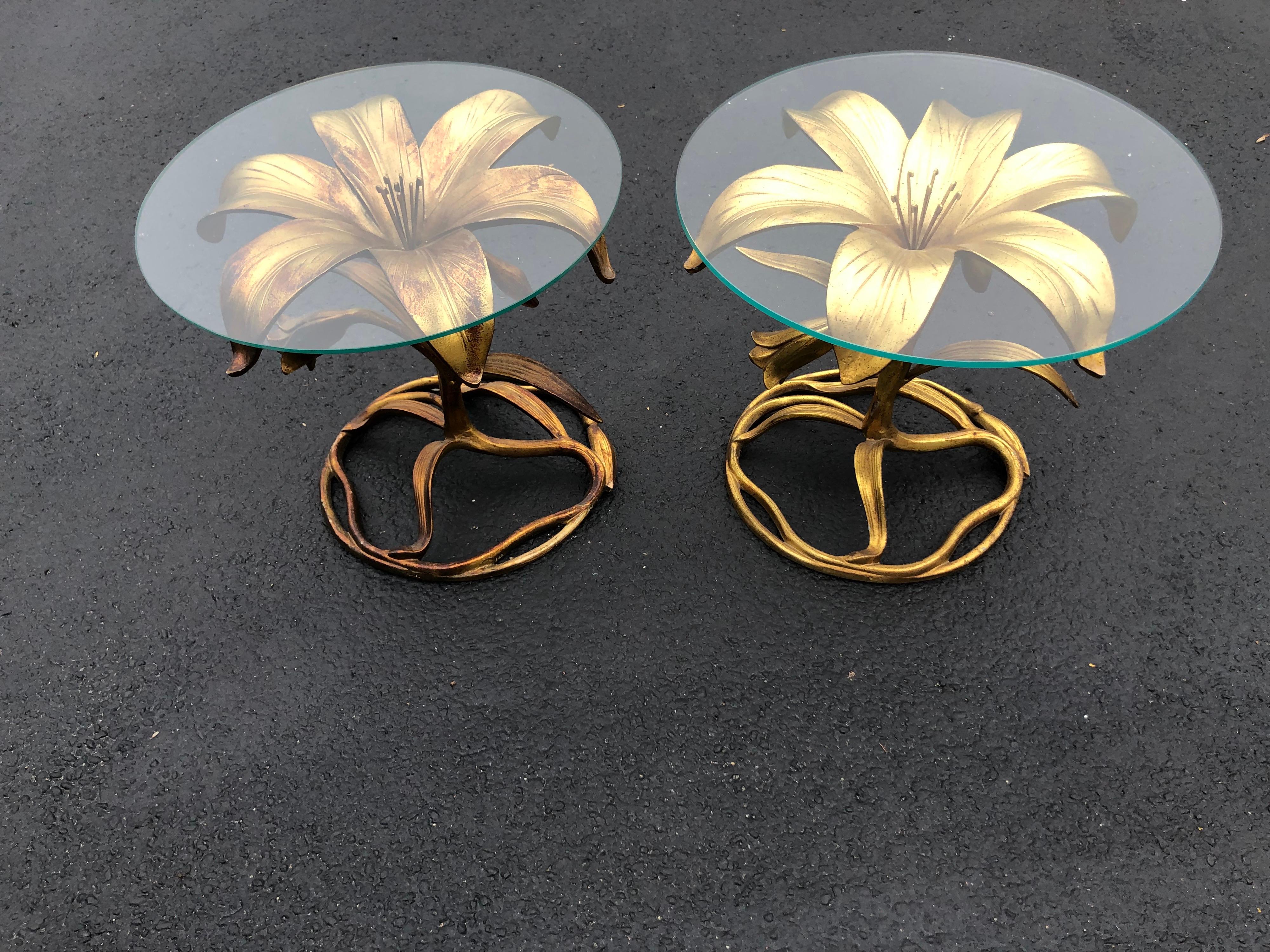 Pair of Arthur Court gilt Lily tables. These each have round tops and a gilt aluminum base. There are variations to the tone and gilding on each table. They are not completely identical in tone but have variation. Some of the gilding has become