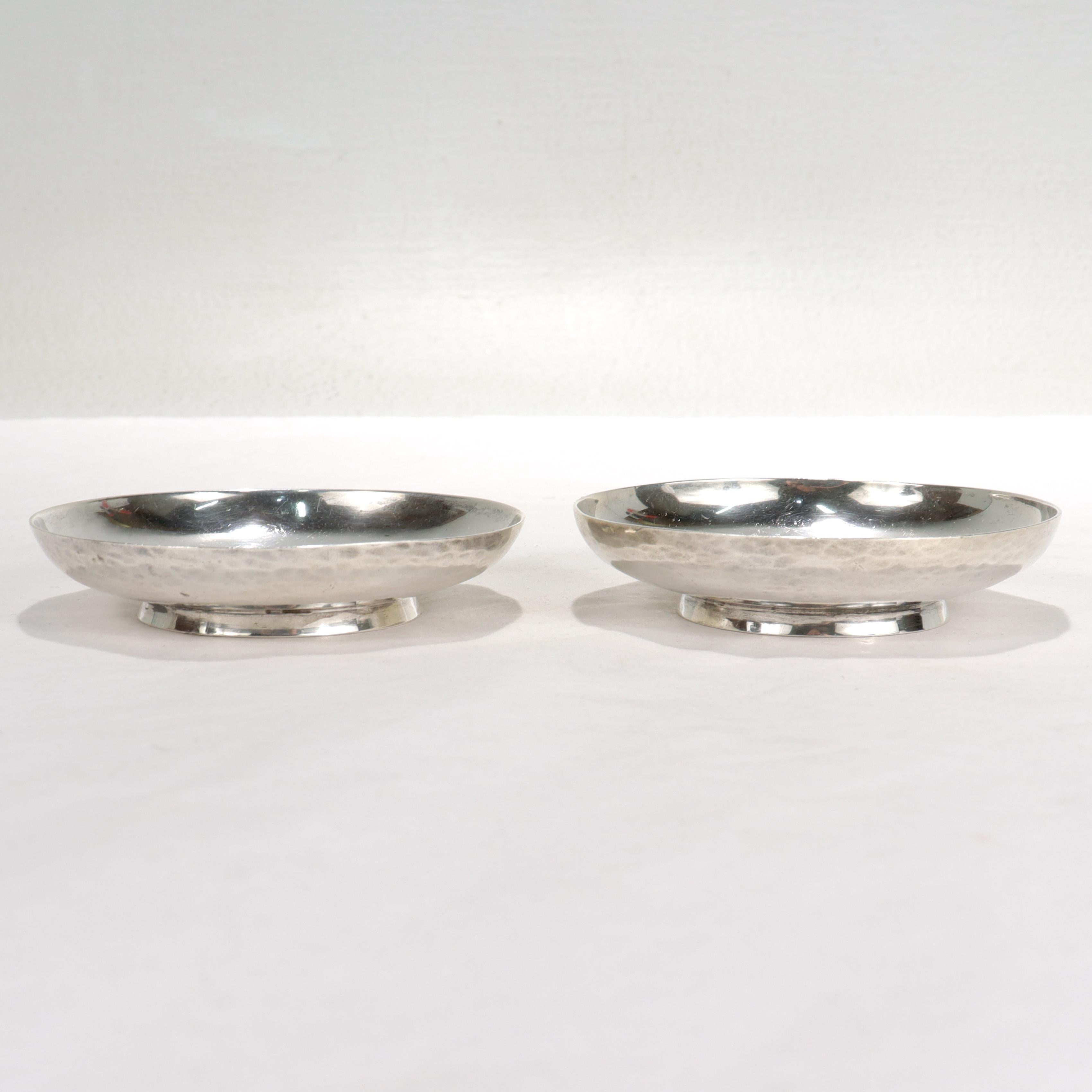A fine pair of olive or nut dishes for the cocktail bar.

By Arthur Stone.

In hand-hammered sterling silver.

Each hand-hammered bowl has a small flared foot and a 'berries & vine' etched decoration to its center. Curiously, the central decoration