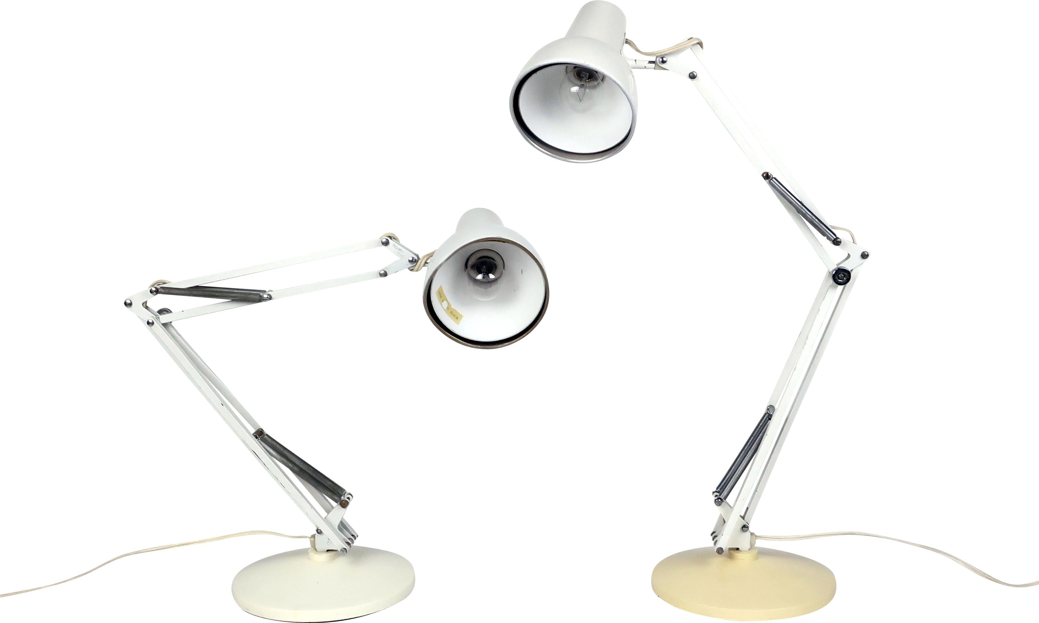 A pair of off-white Luxo desk lamps, one with a cream base and one with an off-white base. This design is similar to the Luxo L-1 lamp, which was the inspiration for the iconic Pixar animated short 