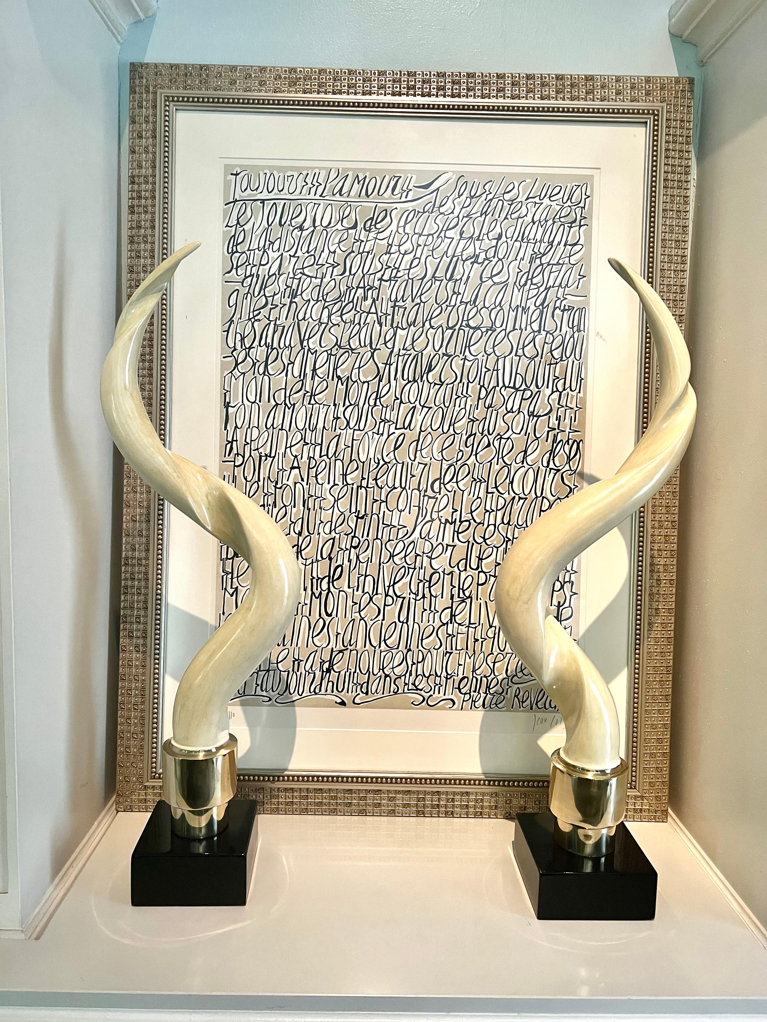 A pair of Kudu Horns on Bases.  The pair were acquired recently and we refinished the horns from Black Lacquer to a more natural faux finish... The bases are wooden black lacquer with an addition to the base which is polished brass. 

The pair would