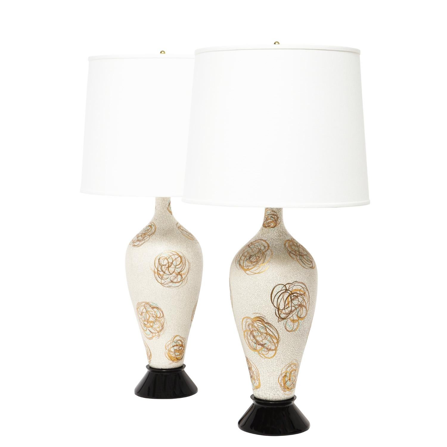 Pair of artisan table lamps, gray speckled glaze with abstract gold flowers on ebonized bases and brass hardware, American 1950's. The colors and glaze on these lamps are simply beautiful. Bases have been newly refinished and lamps have been