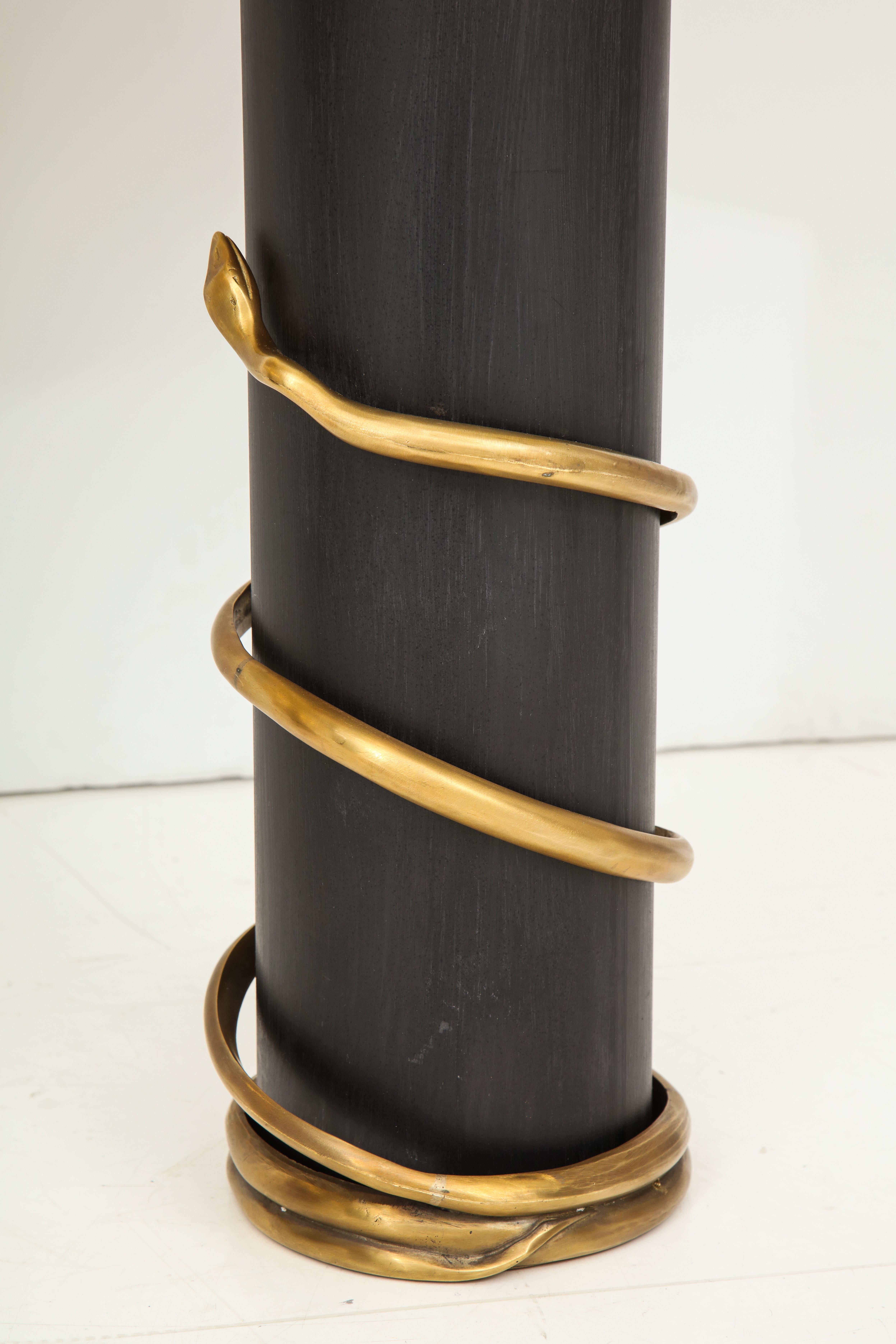 One of a kind pair of lamps each consisting of a black enameled metal cylinder shaped base which is wrapped by a solid brass snake. Artistic and sculptural in nature and handcrafted by an artisan in Florence, Italy. Custom made Italian black drum