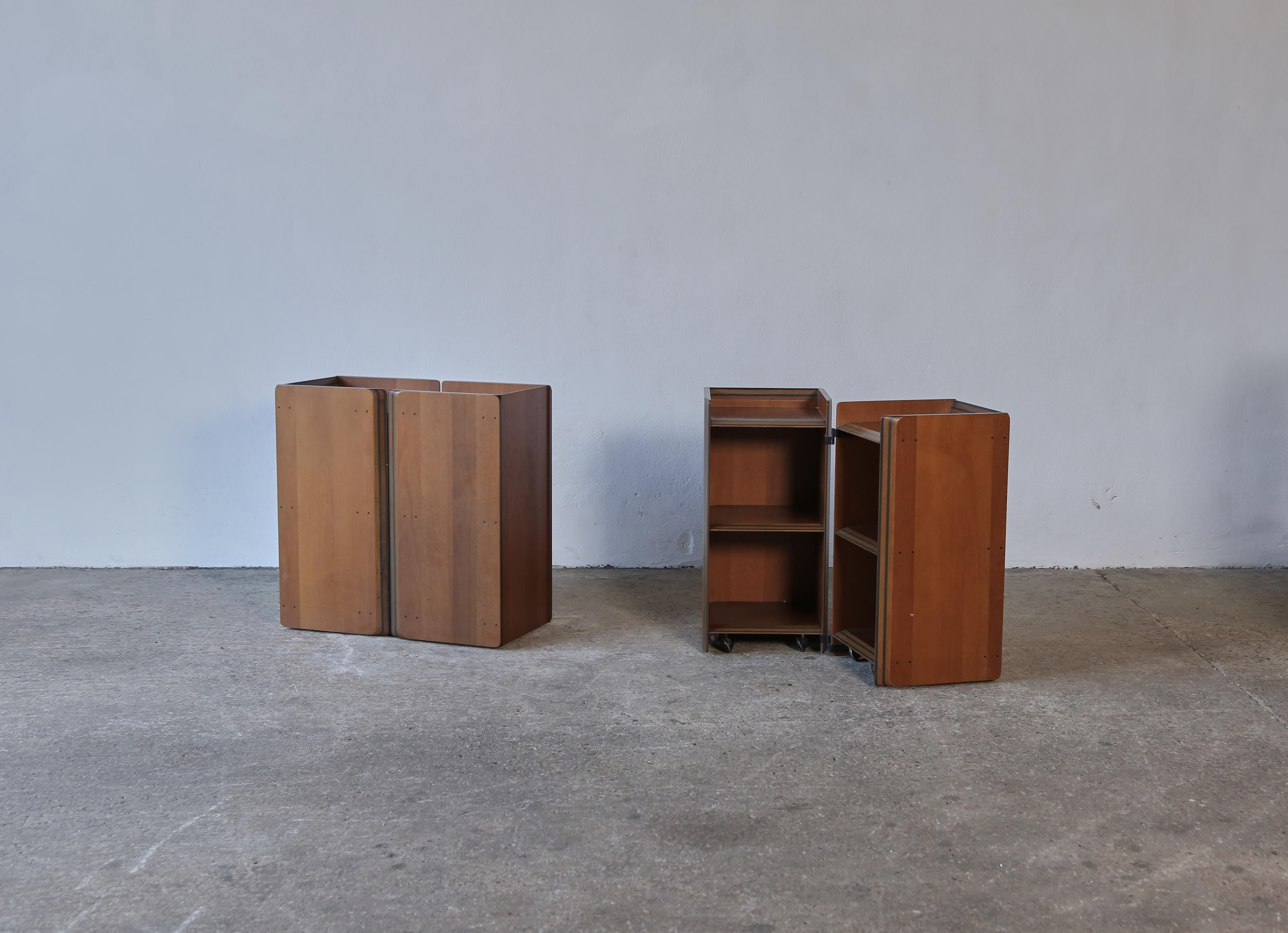 A rare, stylish and very practical pair of folding nightstands or side tables by Afra and Tobia Scarpa from the Artona series, produced by Maxalto Italy, 1970s. The nightstands are on smooth discreet wheels and fold in and out to reveal storage. In