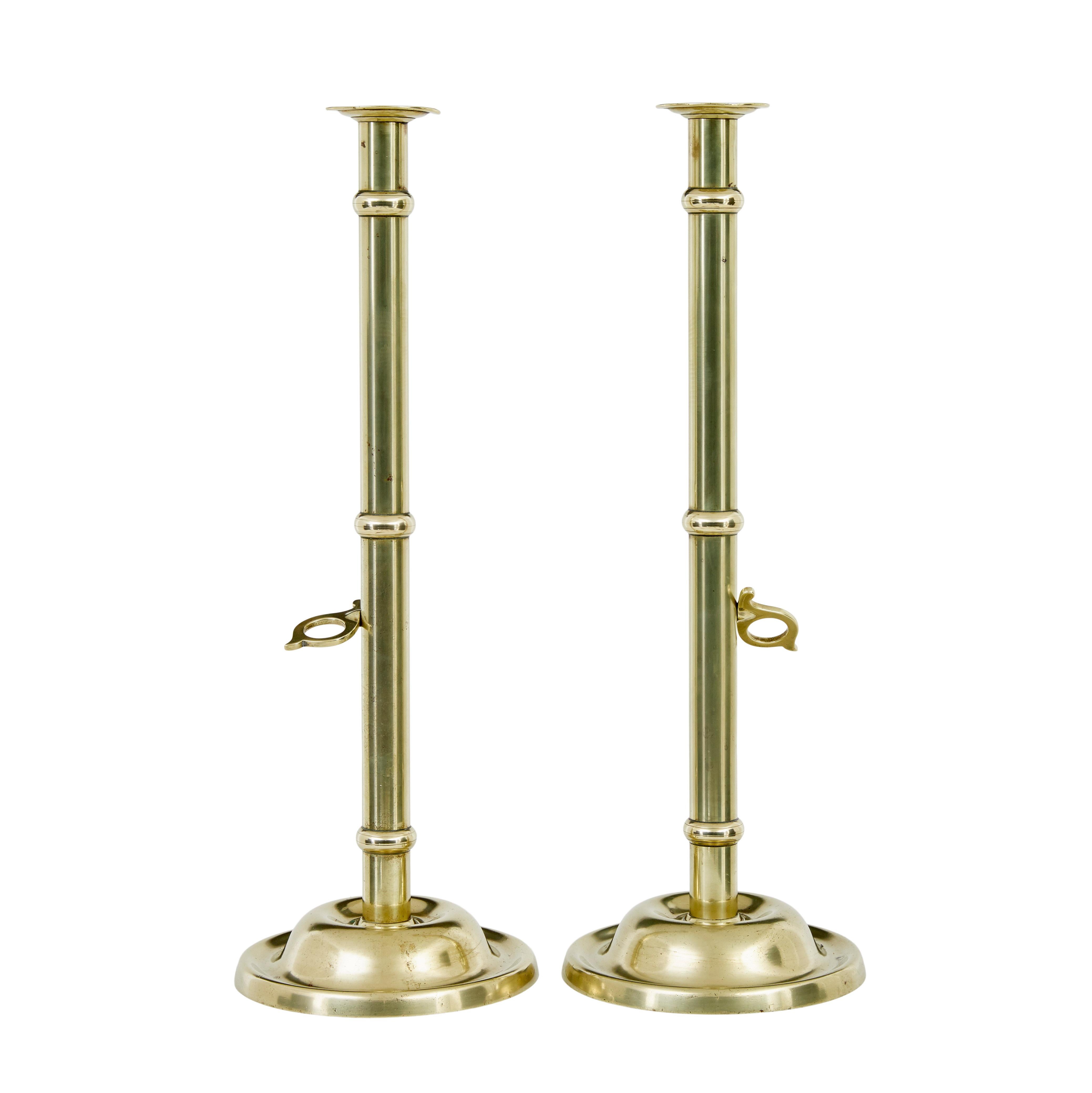 Pair of arts and crafts 19th century brass candlesticks circa 1890.

Good quality pair of tall table or fireside candlesticks made in solid brass.  Elegant pair with the added feature of a sliding trigger which allows the candle to be lifted when