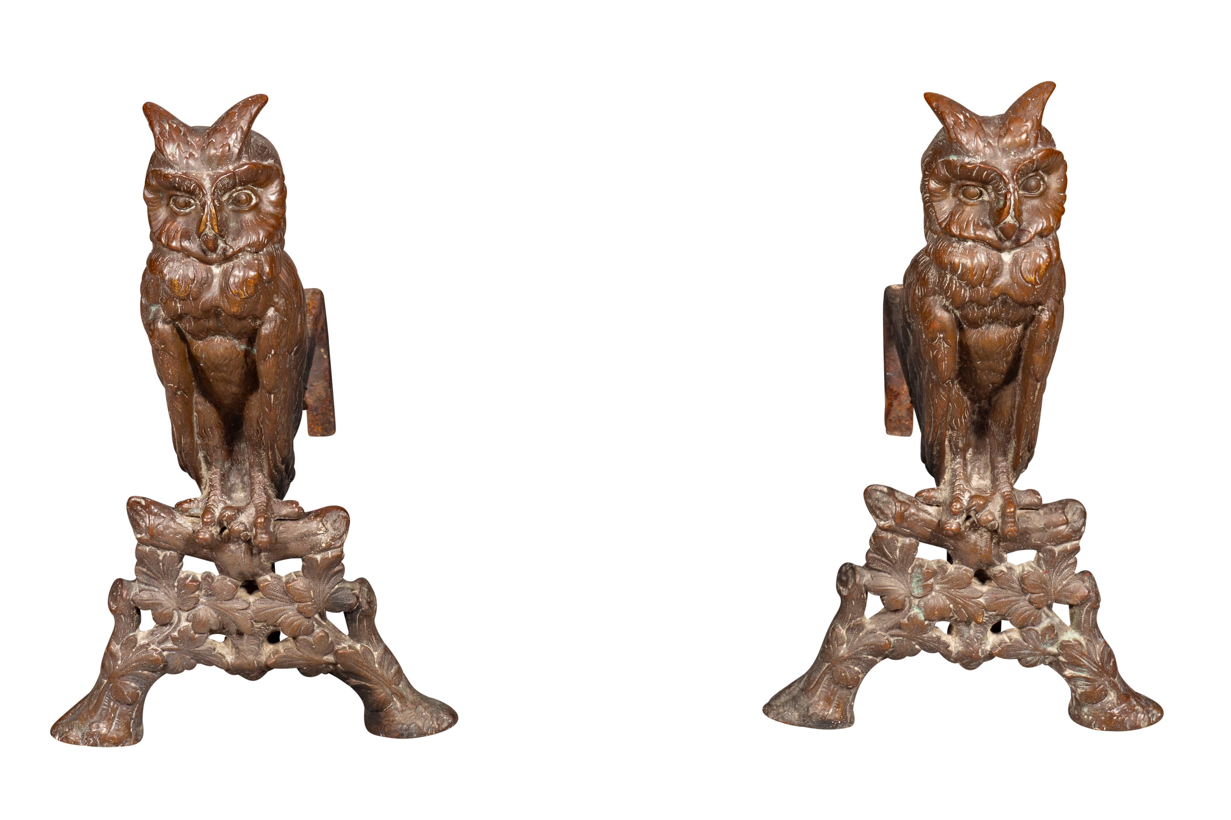 Standing owls on branch and leaf form base. Iron log supports. Brown patina.