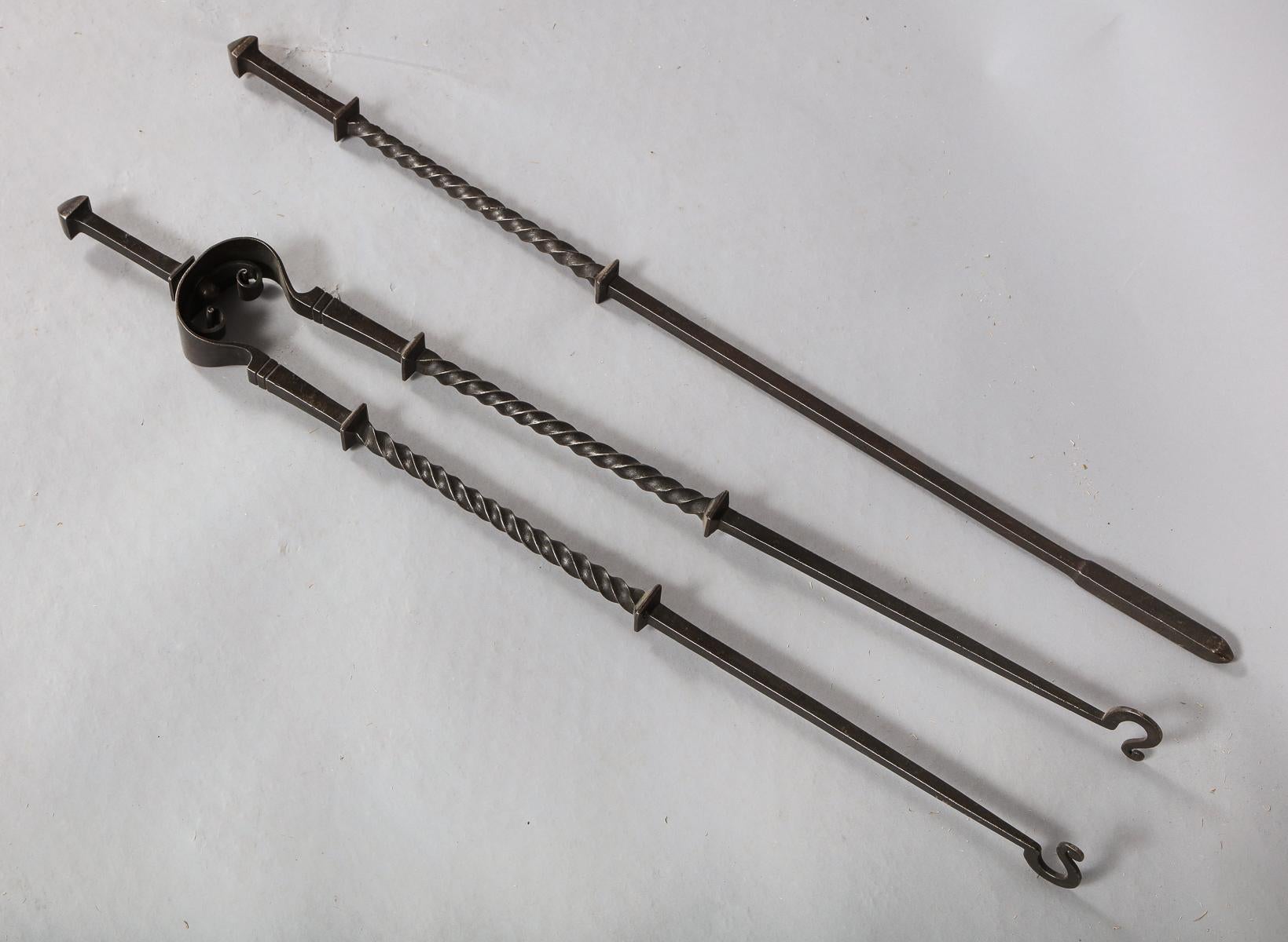 Pine pair of Arts & Crafts period patinated steel fire tools, having square pointed handles over twisted shafts between two square collars, having good, substantial scale.