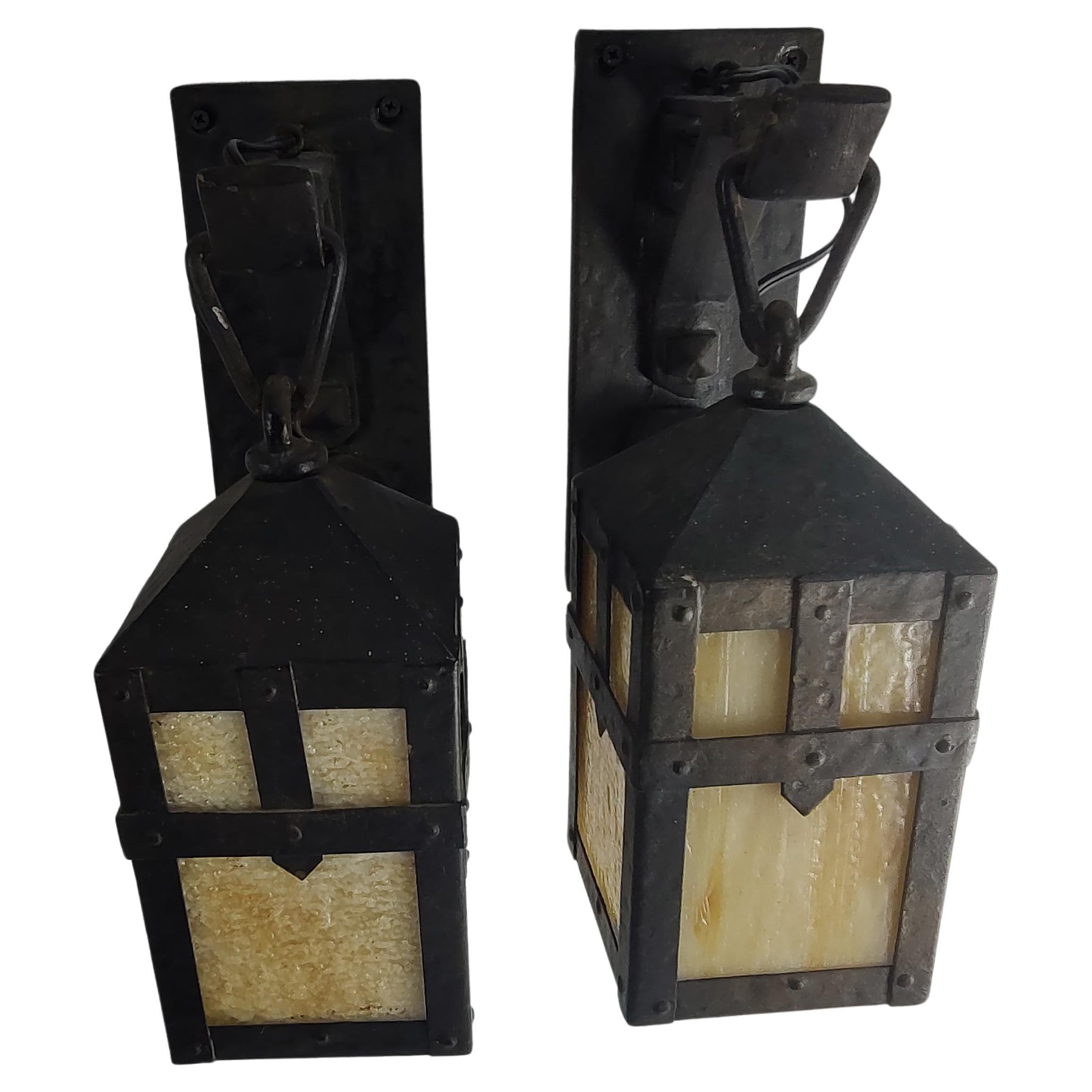 Fabulous and very rare to the market an original pair of sneering Monks Heads brass wall sconces by Gaumer of Philadelphia Pa. 
Aged to perfection (bronze patina) by time and natural elements these brass sconces with caramel slag glass are in