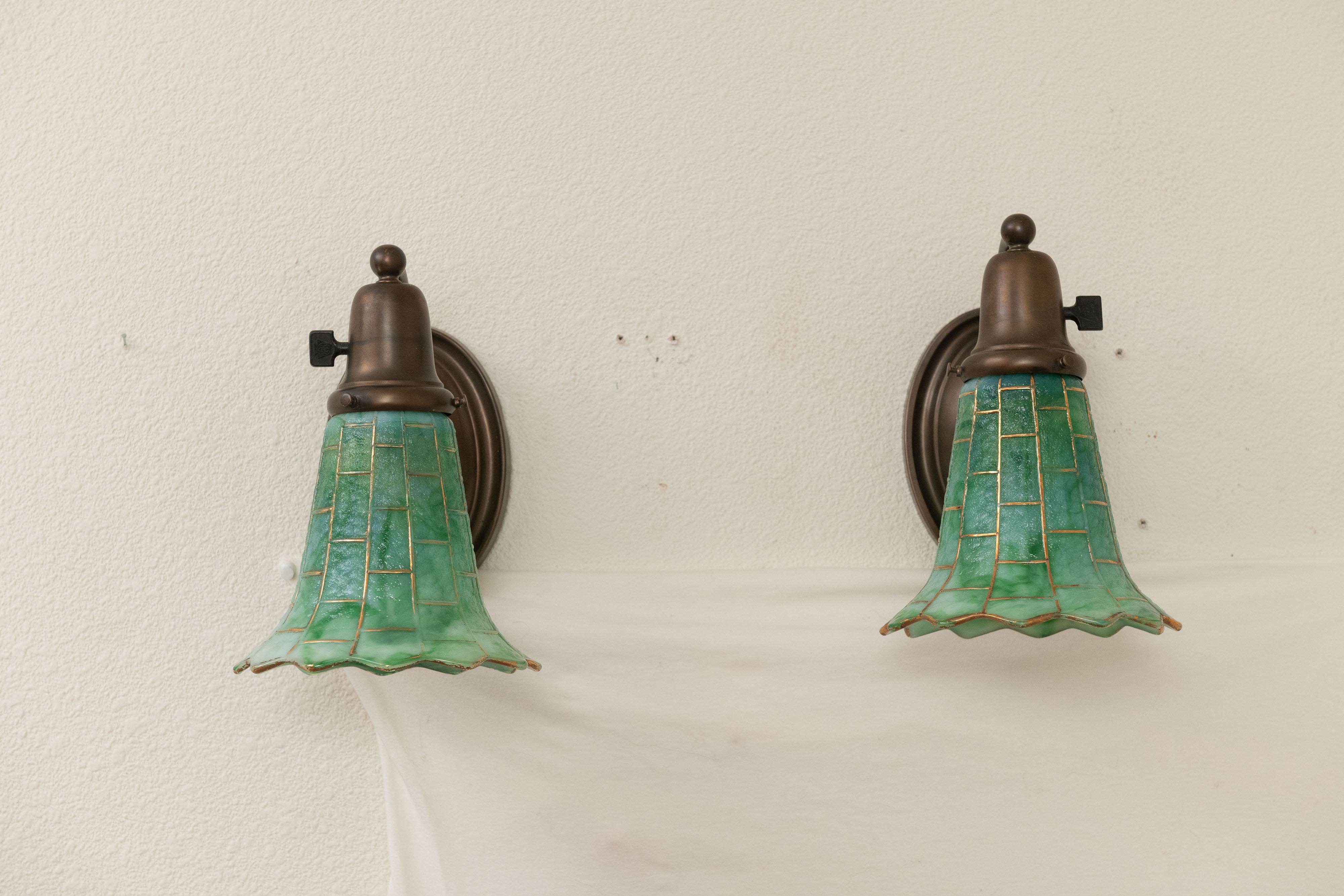 Cette belle paire d'appliques artisanales se compose d'une paire d'appliques en bronze richement patiné et d'une paire exceptionnelle d'abat-jour en verre Kokomo vert. 
  Une belle addition à toute maison et qui peut être utilisée dans n'importe