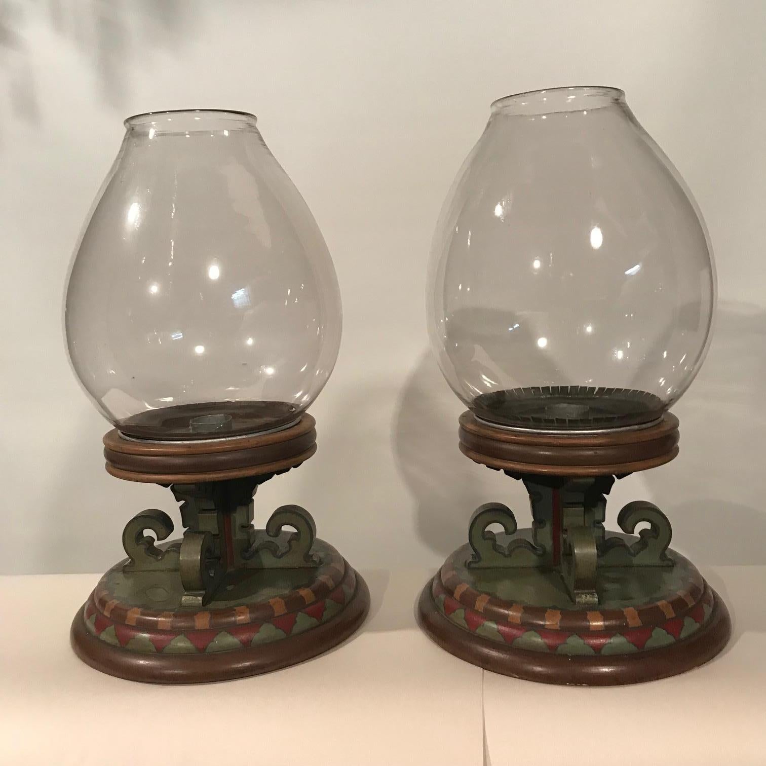 This pair of lamps are quite unlike any we have seen before. Each base is turned in three tapering sizes, supporting an elaborate fret-carved pedestal on which is seated the base of the lamp itself. Countersunk in the base is a tole drip-pan. Each