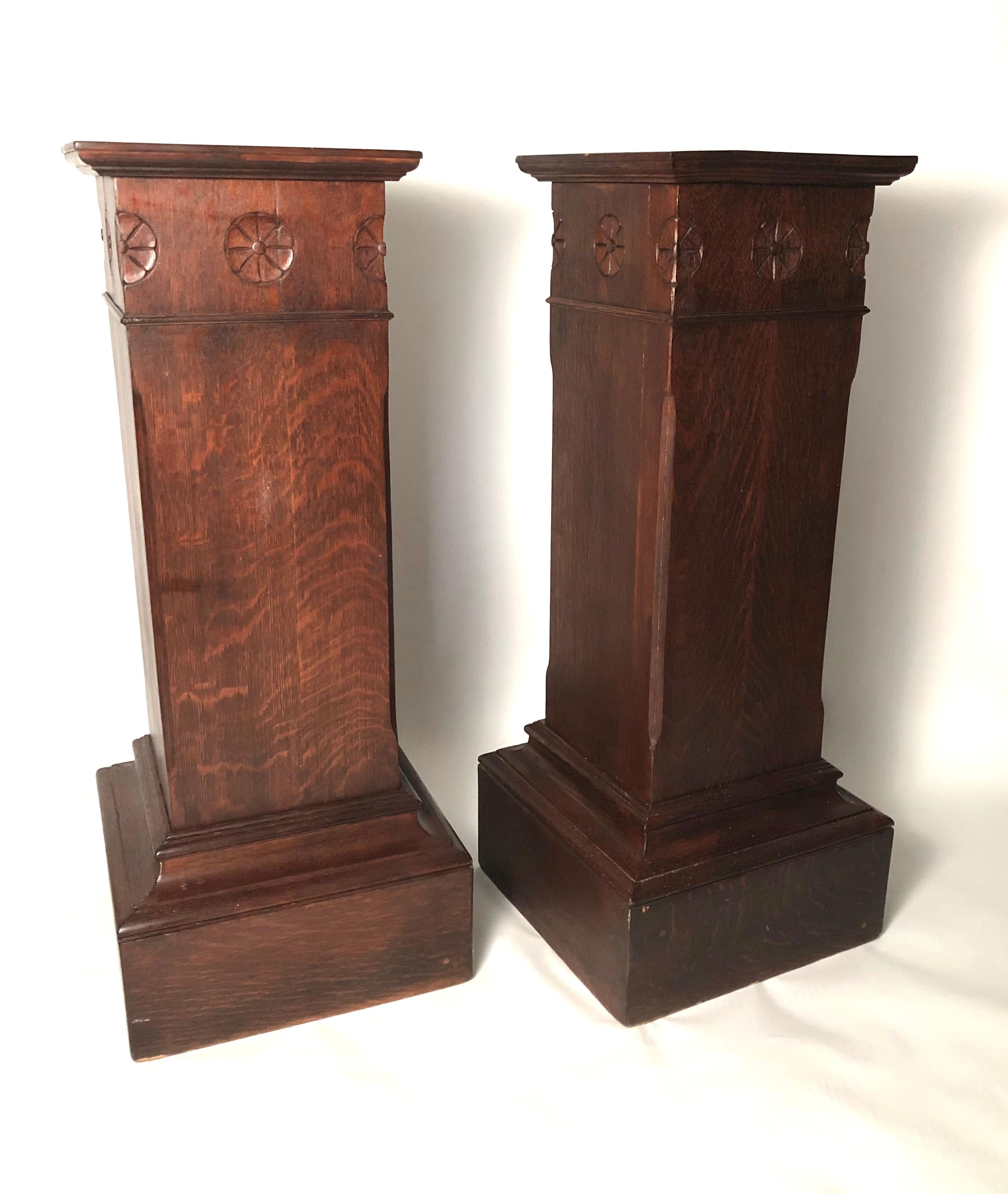 A pair of substantial and beautifully made Arts & Crafts period pedestals in quarter-sawn oak, with carved rosettes at the corners and stepped molding at the top and bottom of each.

Measures: Height 48 inches
Width 20 inches square at bases, 16